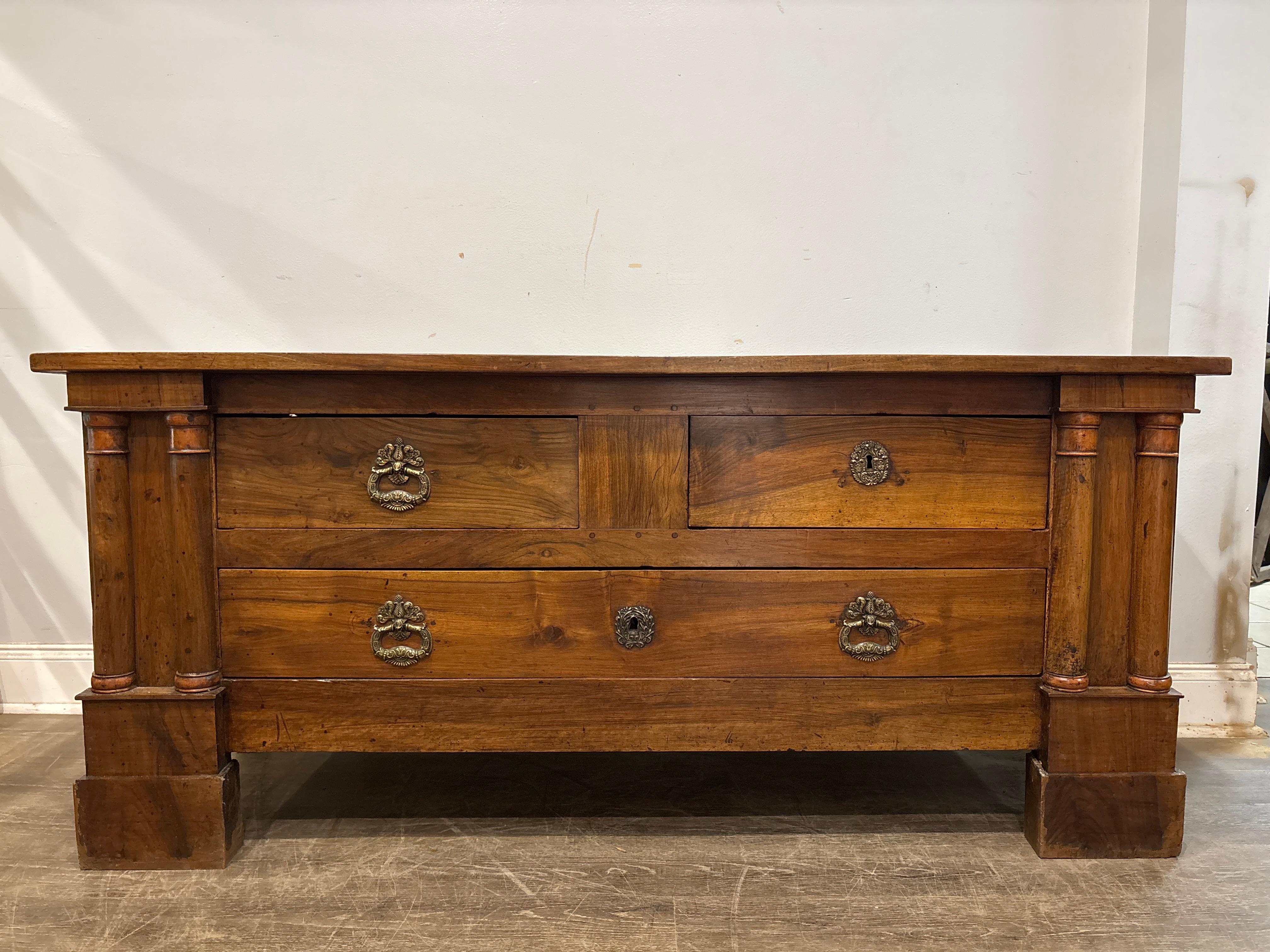 Cette magnifique commode rustique de style Empire français est fabriquée en noyer avec des colonnes doubles de chaque côté.