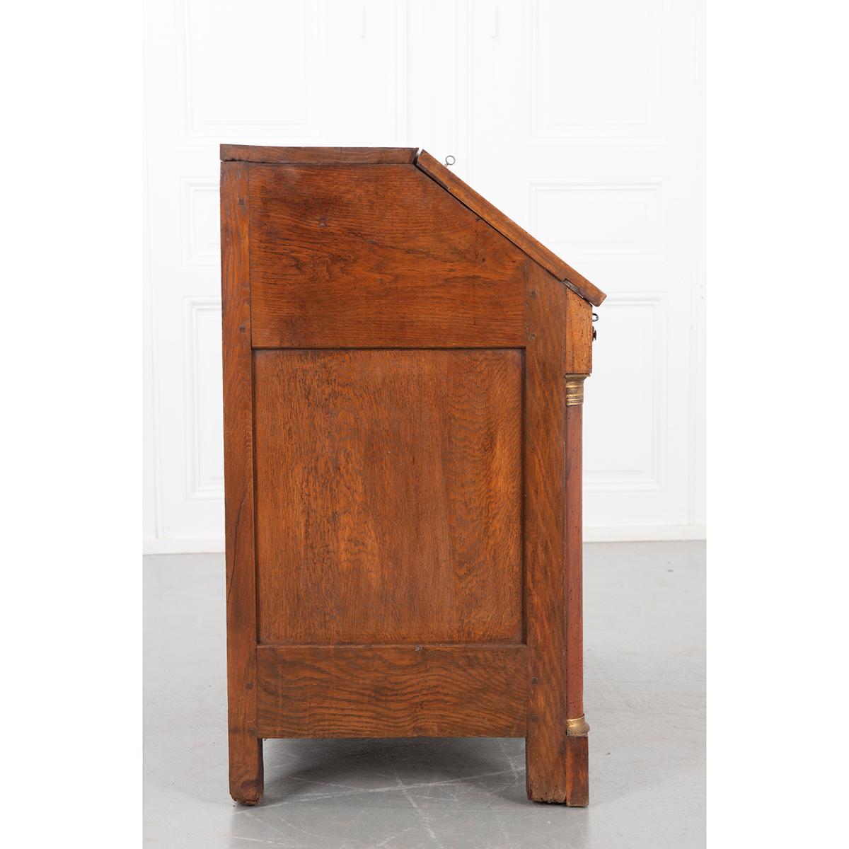 This French 19th century solid walnut desk has many interesting features. The slant front folds down to reveal a writing surface and many small compartments. There are two small drawers at the top sitting over two larger drawers all made of oak.