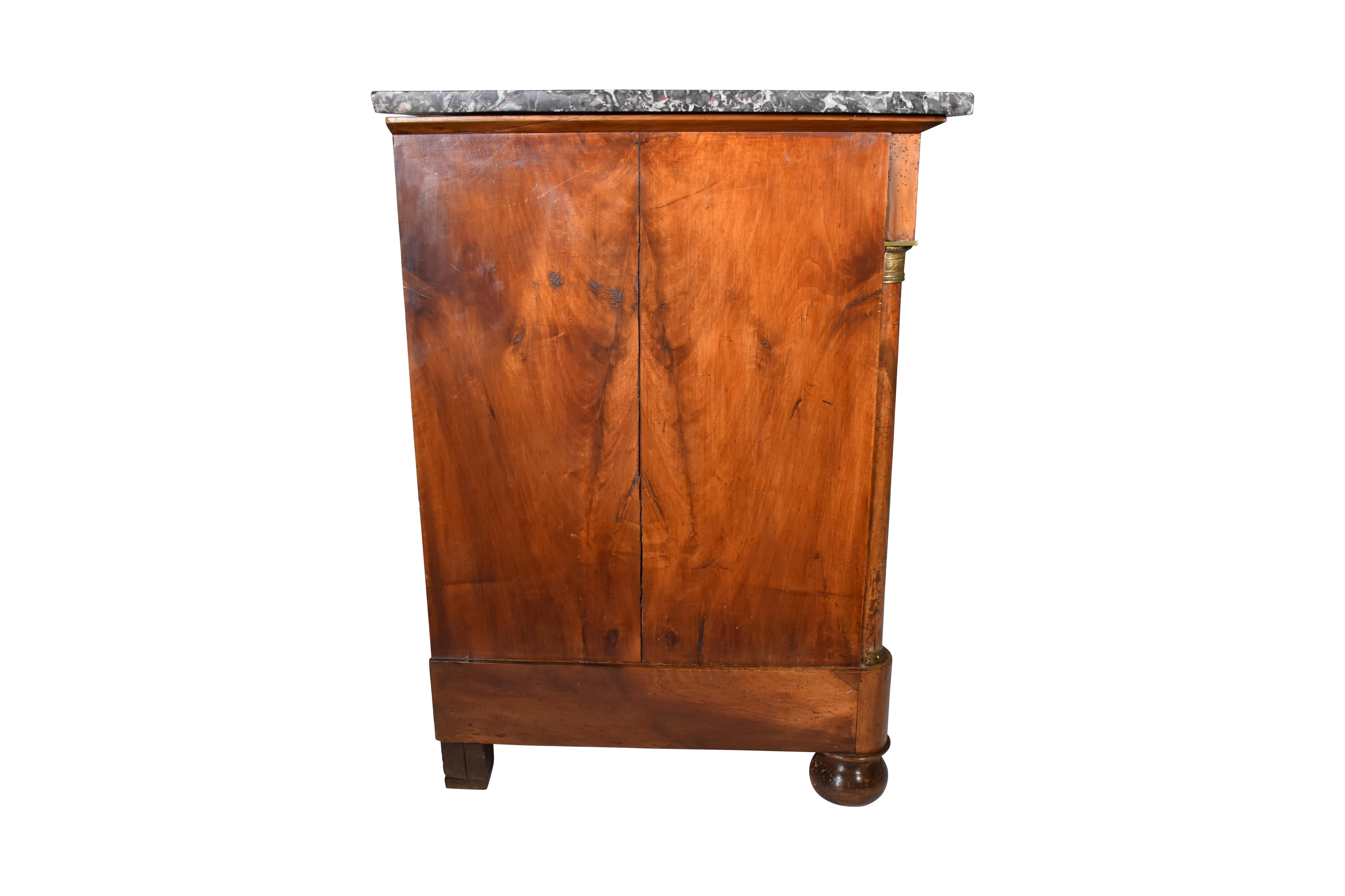 Beautifully bookmarked wood grain sets off each of the three doors of this wonderful French enfilade or buffet that is made of Walnut with a Marble Top. Wood grain details continue on the single drawer accented by brass handles. Ormalou brass