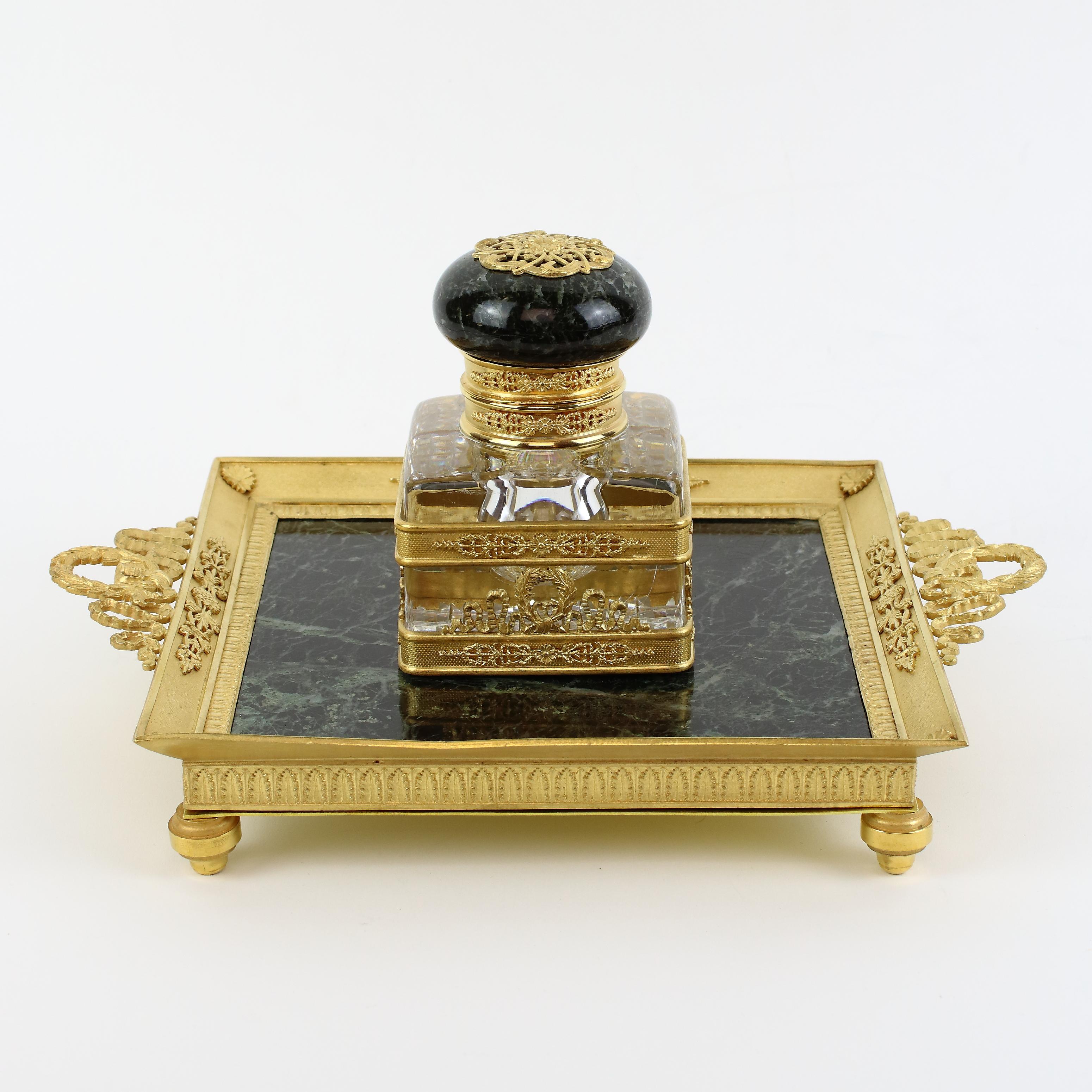 French 19th century Empire gilt bronze crystal marble inkstand attr. Baccarat

Square green marble plate standing on gilt bronze toupie feet with high gilt bronze rim elaborately decorated with neoclassical lanzetto leaf frieze and foliate