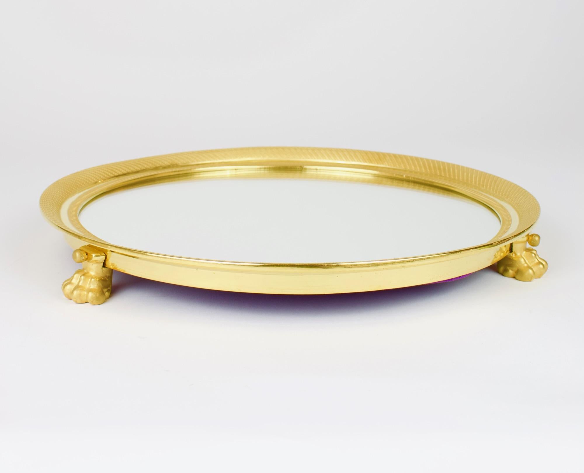 Fine French 19th Century Empire Gilt Bronze Lion Feet centrepiece or Surtout de Table

Round gilt bronze frame with fine guilloche decoration standing on three finely cast lion paws holding a round mirror plate. Back lined with purple felt.