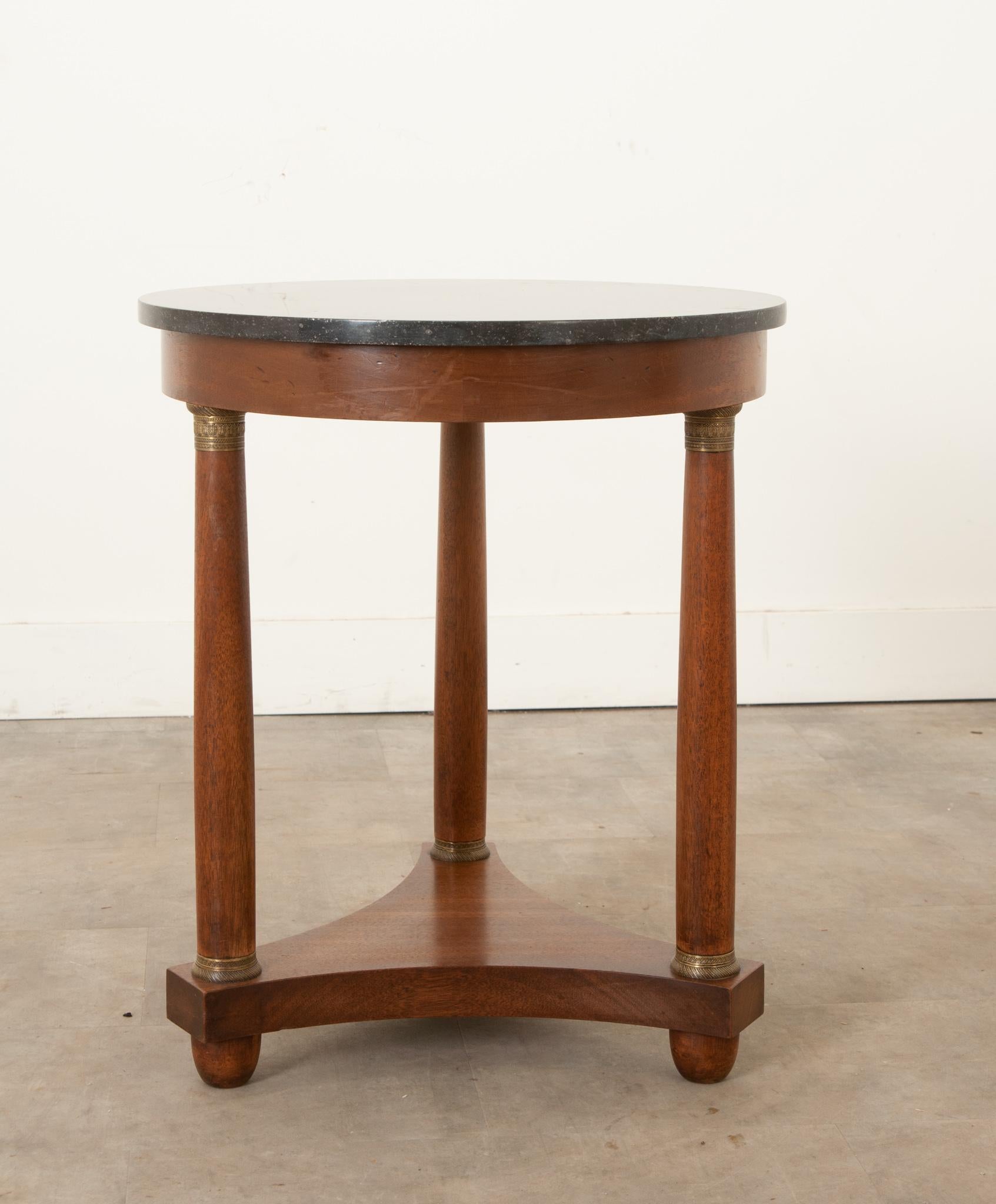 This 19th century Empire gueridon is the perfect addition to any home decor style. Beautiful, black fossil marble tops the rich mahogany base, the marble has been professionally repaired. Three turned column-form legs lift the top, each with highly