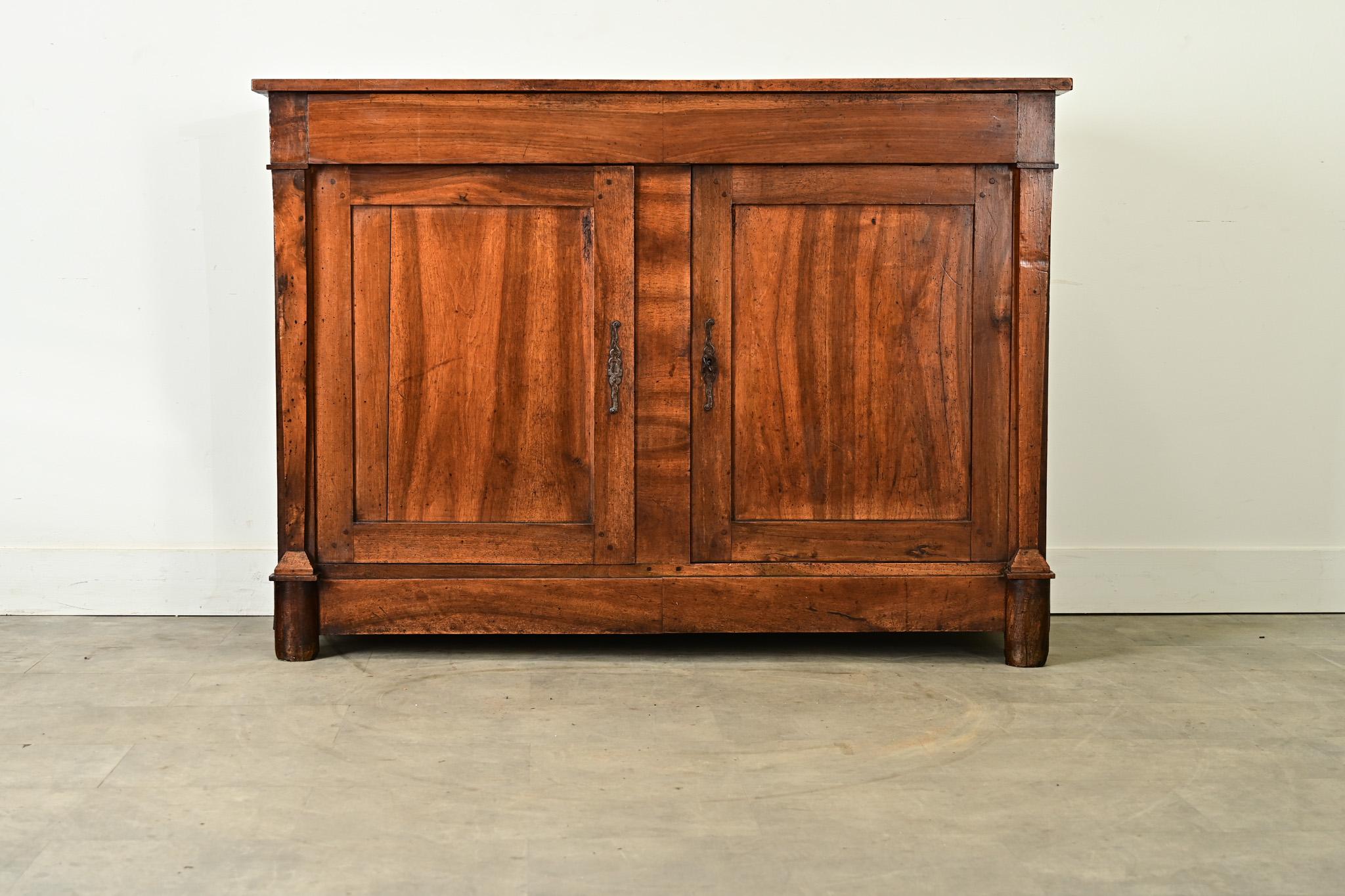 
Un buffet in noce massiccio patinato, che mostra un fascino da Impero francese temperato da Louis Philippe, circa 1860. Il semplice piano a listoni è sostenuto da incastri a vista, caratterizzati da una varietà di nodi nel legno e da due secoli di