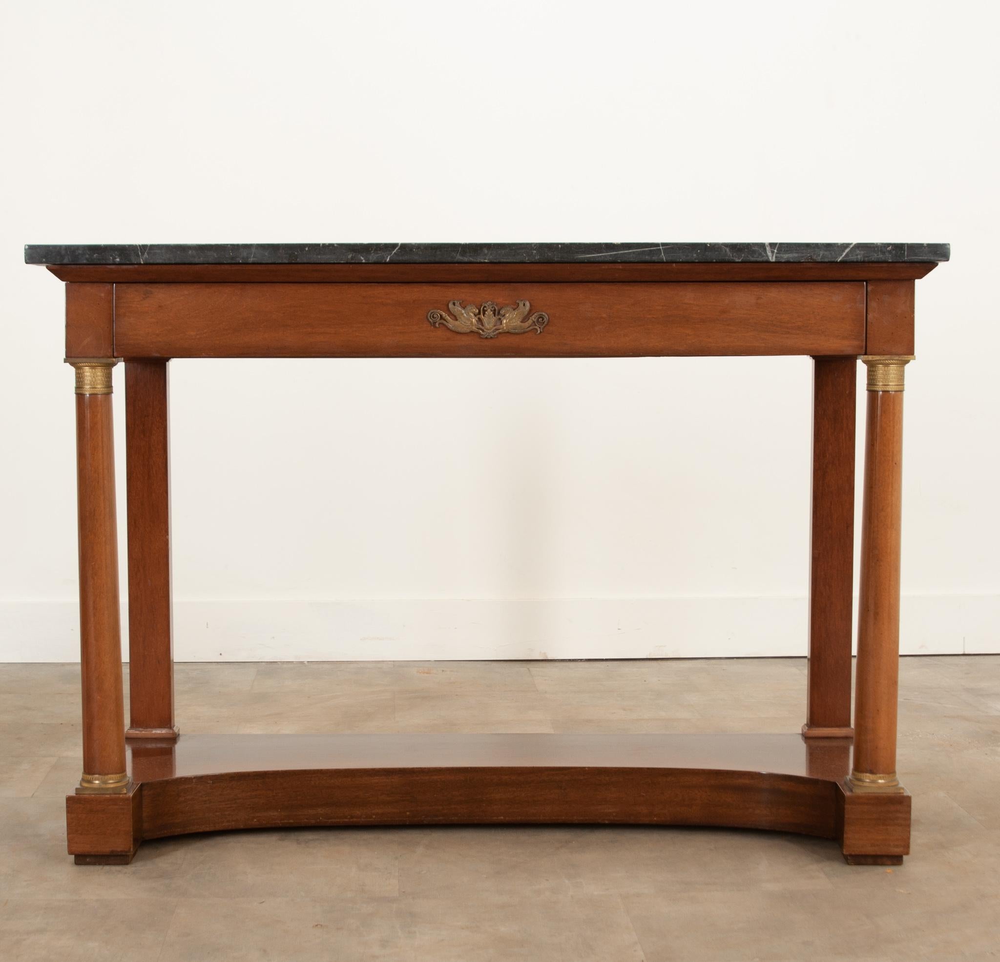 A very handsome marble topped console from France, circa 1830. Empirically styled with wonderful cast brass ormolu on the drawer front and front legs. The vibrant mahogany is in wonderful antique condition and compliments the top nicely. A concave