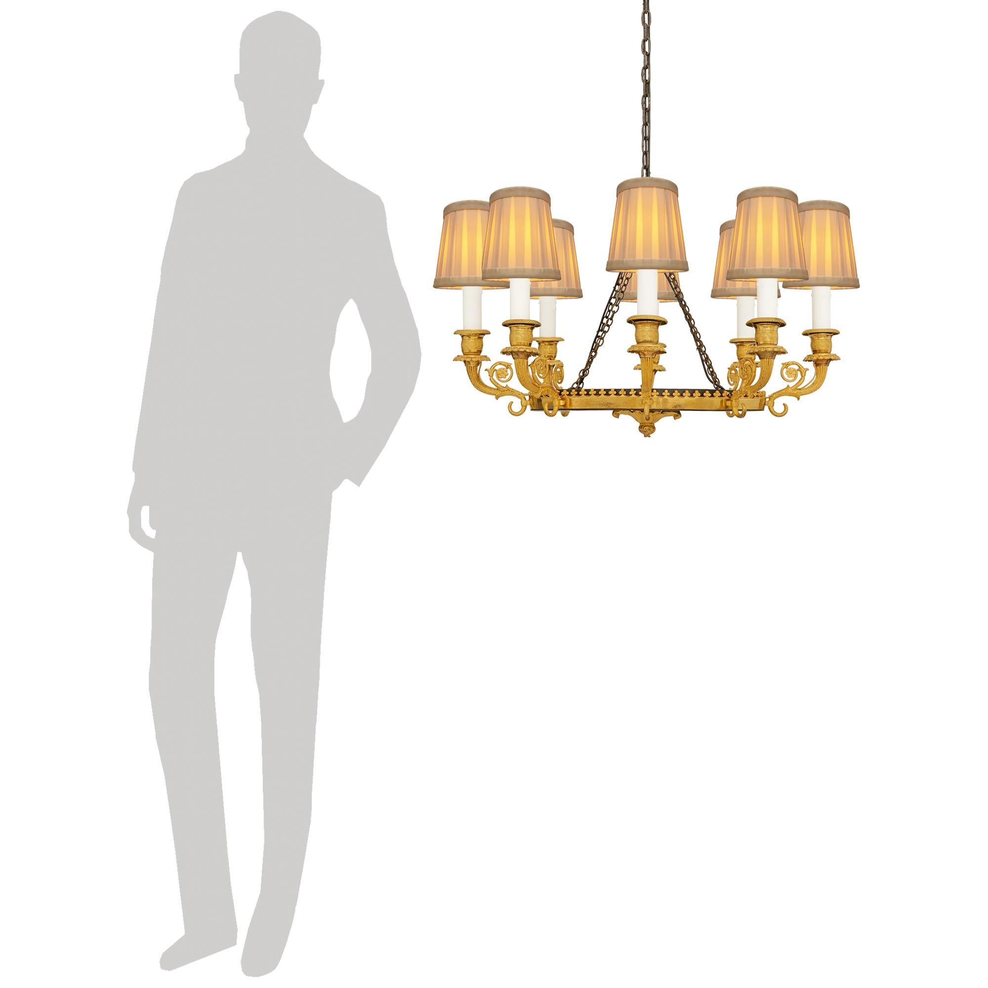 A high quality and most decorative French 19th century Empire Period patinated Bronze and Ormolu chandelier, circa 1805. This wonderful eight light oval shaped chandelier is centered at the bottom by a richly chased foliate finial below the