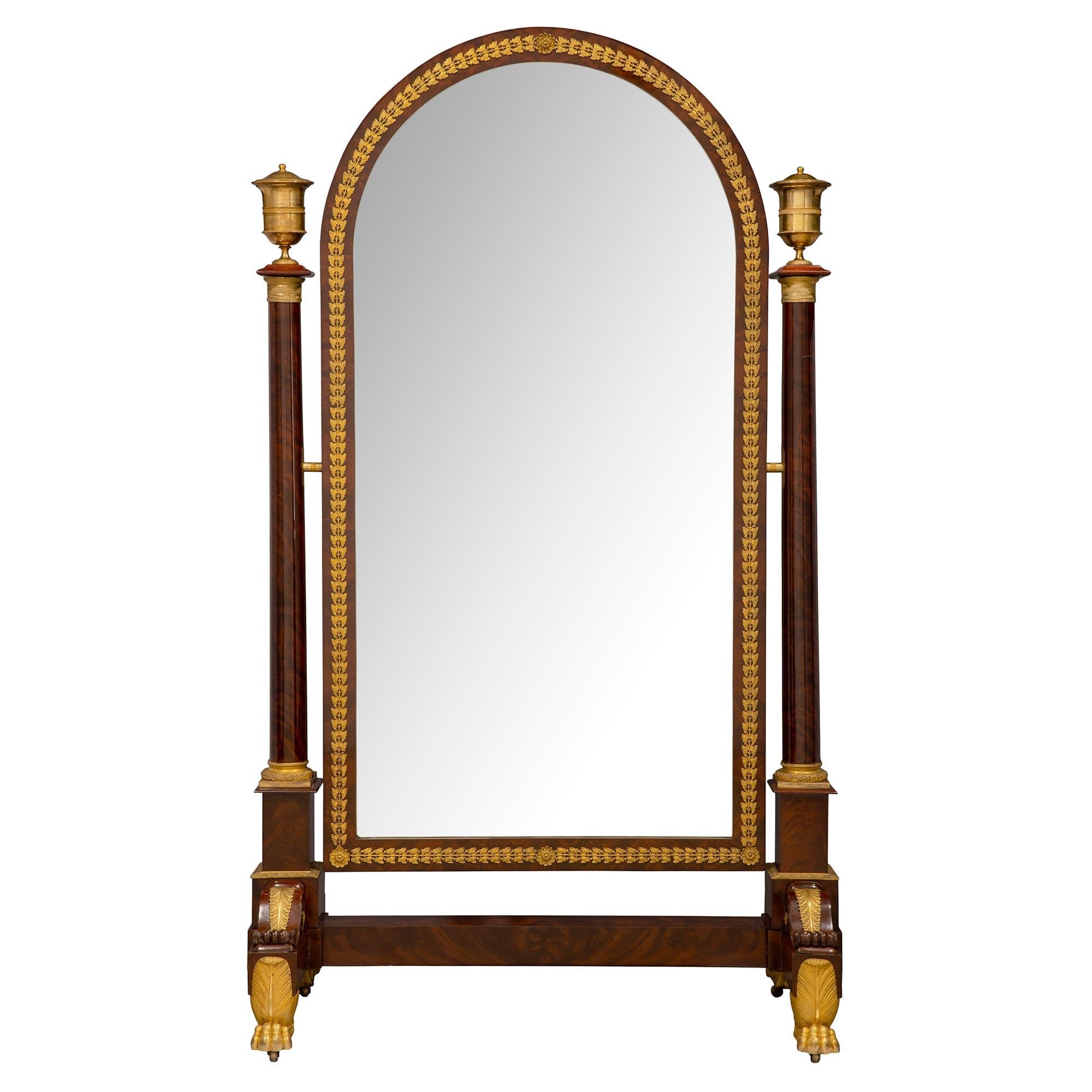 Un sensationnel miroir Psyché en acajou monté en bronze doré, d'époque Empire, du XIXe siècle. Le miroir est surélevé par un impressionnant support en bronze doré, sous une épaisse base en acajou et des sculptures en 