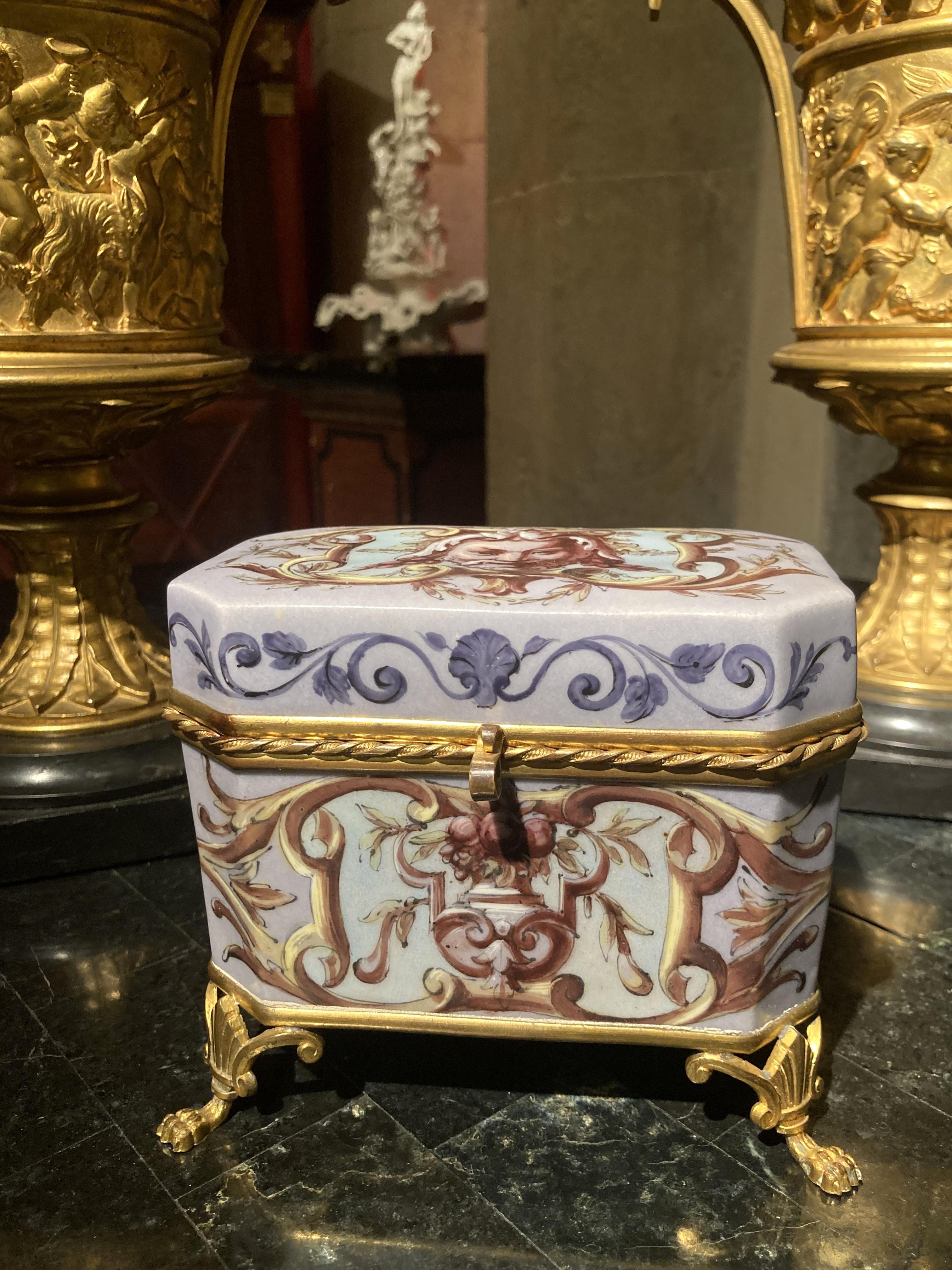 This French Empire 19th century rectangular porcelain dresser box or jewlery decorative casket has a wonderfully patinated powder blue/cerulean light blue background color and features grotesque masks, architectural vase, fruit, flowers and leafy