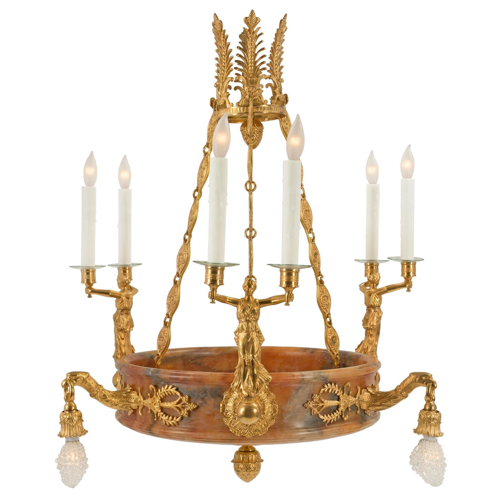 A handsome and impressive French 19th century Empire st. alabaster and ormolu twelve light chandelier. The chandelier has a circular dome with curved bottom and a central ormolu finial. The dome with mottled edges, is richly decorated by electrified