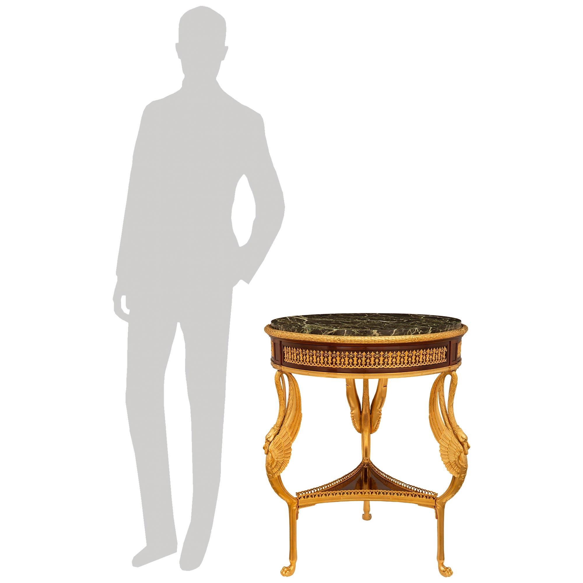 Magnifique table d'appoint en acajou, bronze doré et marbre Verde Antico d'époque Belle Époque et de style Empire du XIXe siècle. Cette magnifique table à un seul tiroir repose sur trois pieds cabriole en bronze doré contenant des cygnes ailés