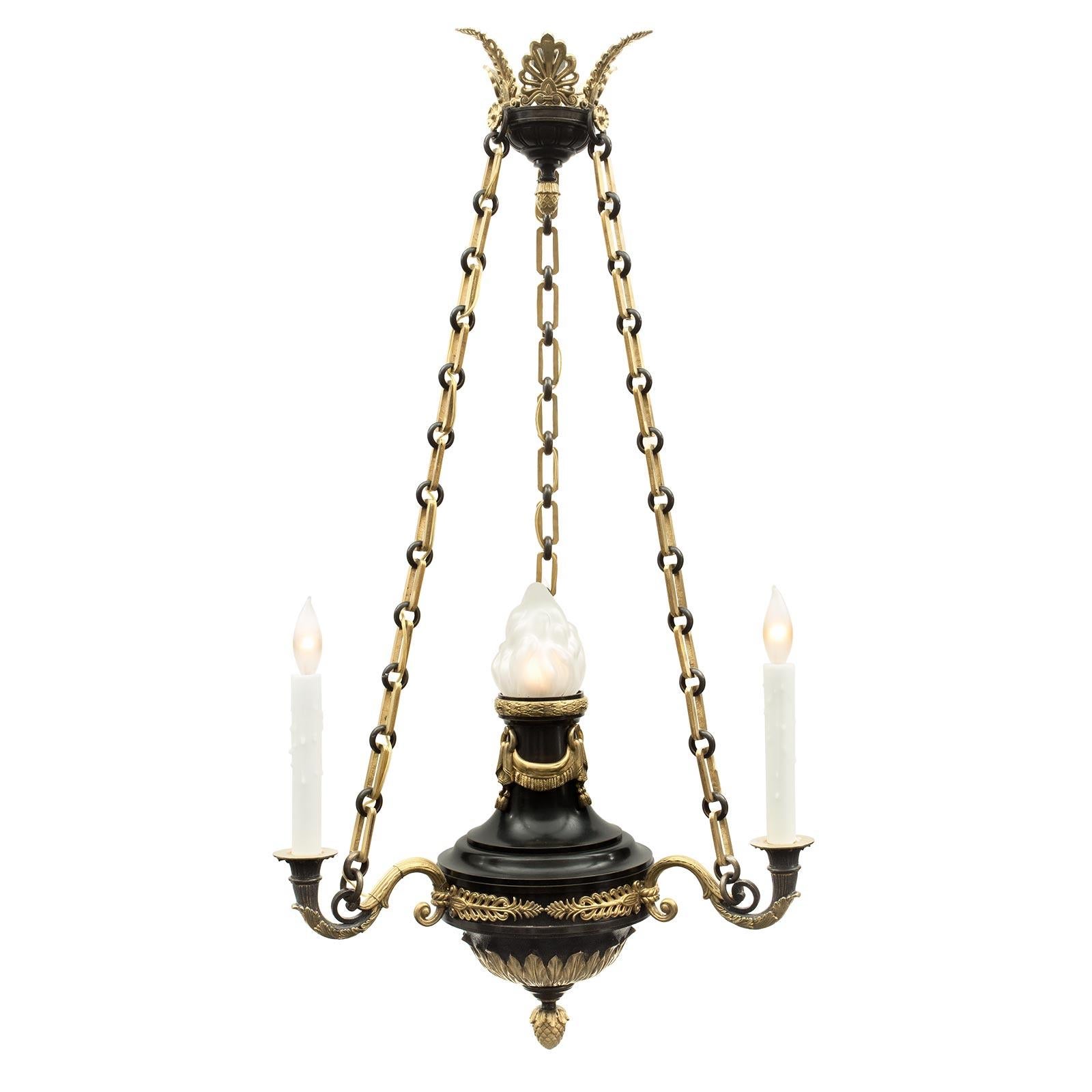 A lovely French 19th century Empire st. verdigris patinated bronze and ormolu chandelier. The patinated bronze base is decorated with an ormolu inverted finial and acanthus leaves and foliage. Above the three S scrolled arms are centered by a