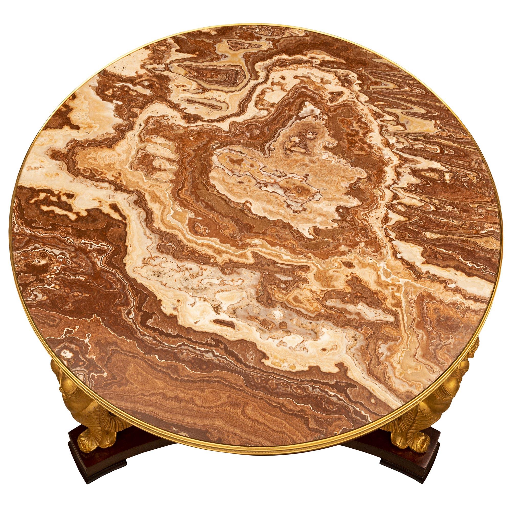 Ein hübscher und beeindruckender französischer Empire-Tisch aus dem 19. Jahrhundert aus Mahagoni, Goldholz, Ormolu und Alabastro-Marmor. Der runde Tisch steht auf eleganten Kugelfüßen unter der dreieckigen Bodenplatte mit den schönen konkaven
