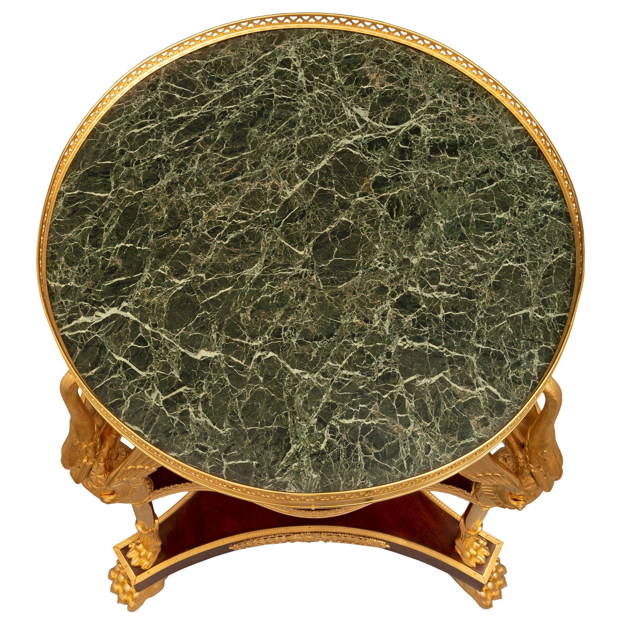 Exceptionnelle et unique table d'appoint en acajou, bronze doré et marbre Vert de Patricia de style Empire du XIXe siècle. La table est surélevée par de beaux pieds en patte d'oie en bronze doré sous une fine rosace et un élégant plateau