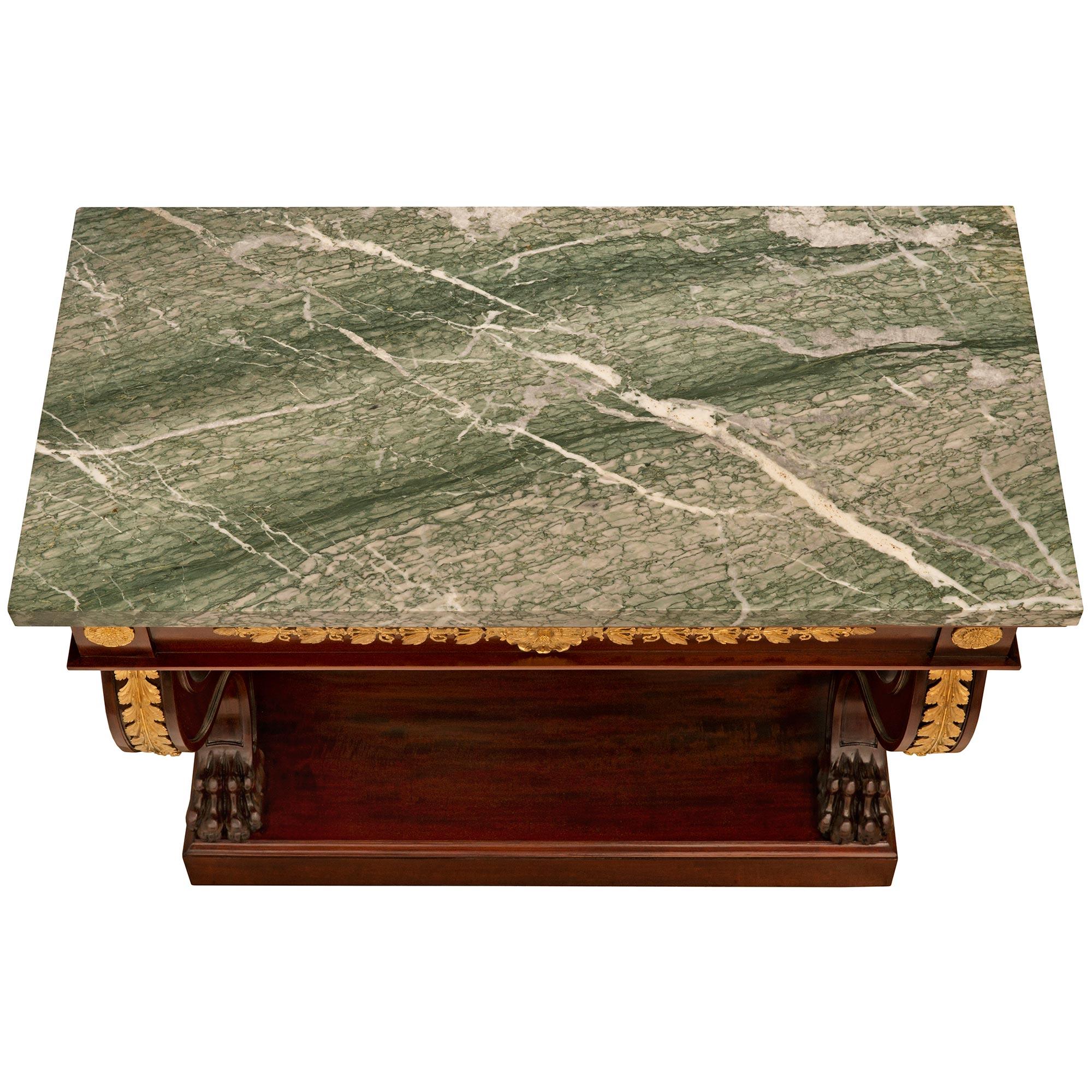 A handsome French 19th century Empire st. Mahogany, Ormolu and Vert Campan marble console. The solid Mahogany console is raised on a rectangular plinth with a mottled edge on the three sides. Above are the 'S' scrolled front supports ending with