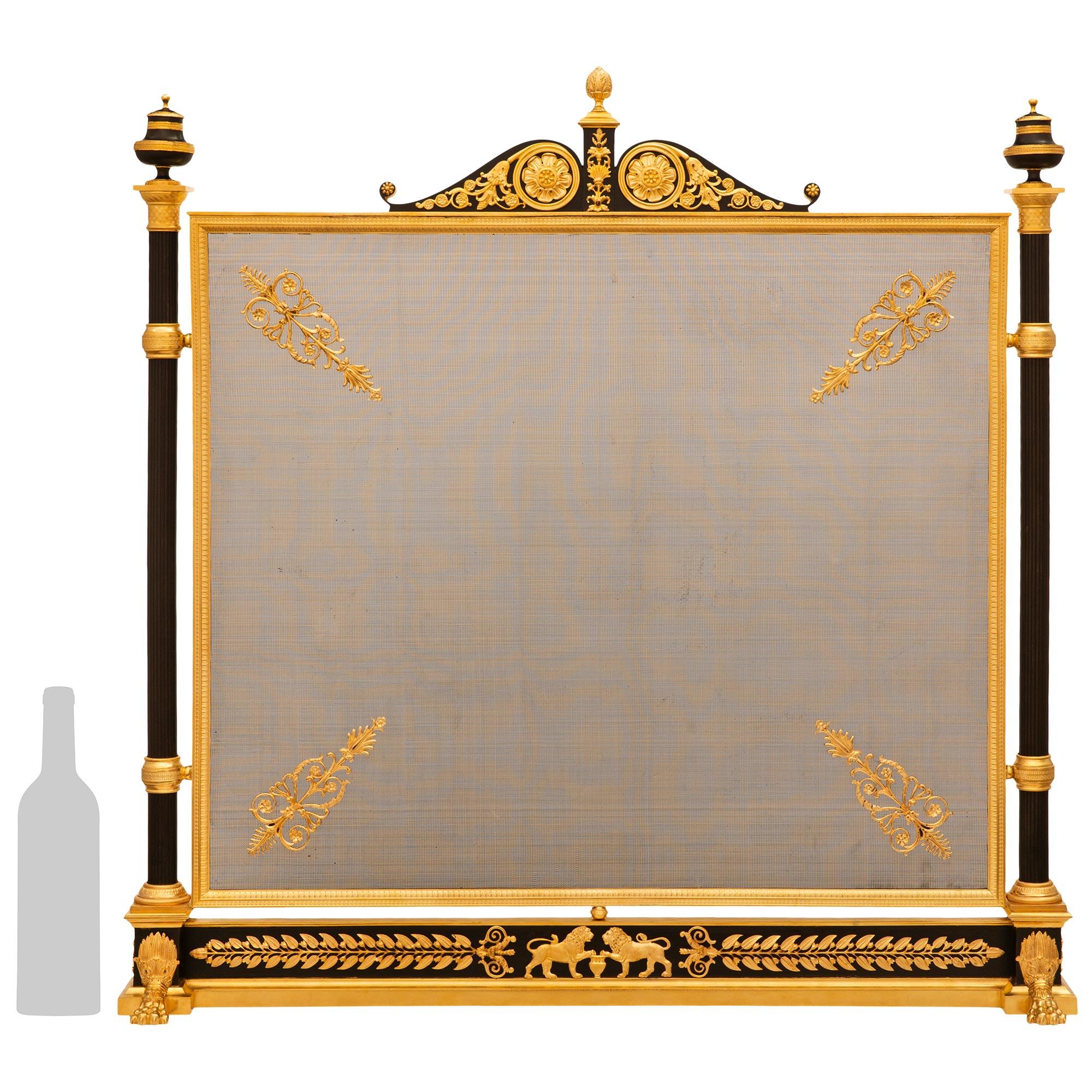Très bel écran de cheminée en bronze patiné et bronze doré, de style Empire, datant du XIXe siècle. Ce superbe écran de cheminée carré repose sur une longue et mince base rectangulaire en bronze patiné, rehaussée d'un socle en bronze doré à bords
