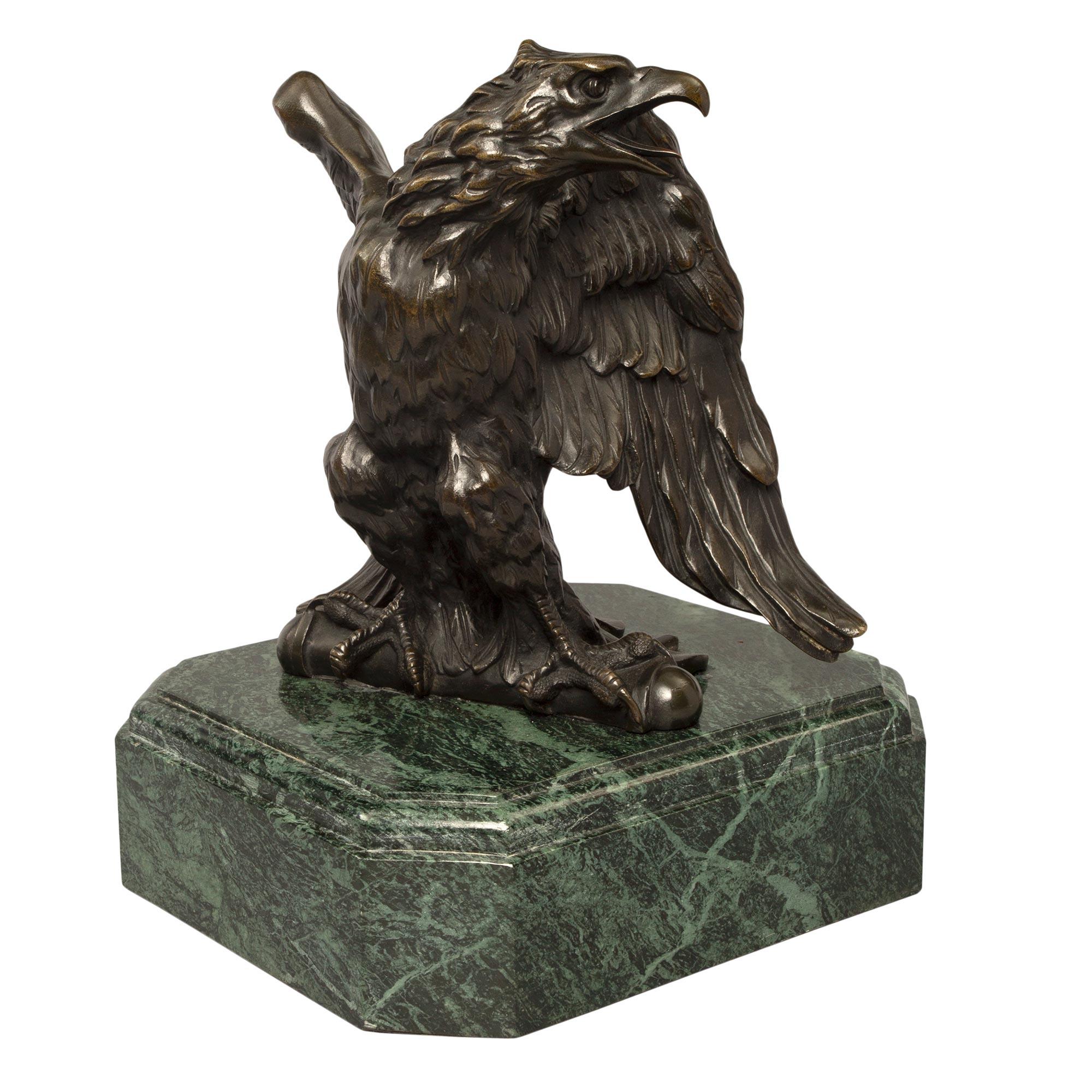 Bellissima aquila in bronzo patinato stile Impero della metà del XIX secolo su una base in marmo Vert de Patricia. L'aquila riccamente dettagliata è sollevata da un'imponente base quadrata screziata Vert de Patricia con angoli tagliati. L'aquila ad