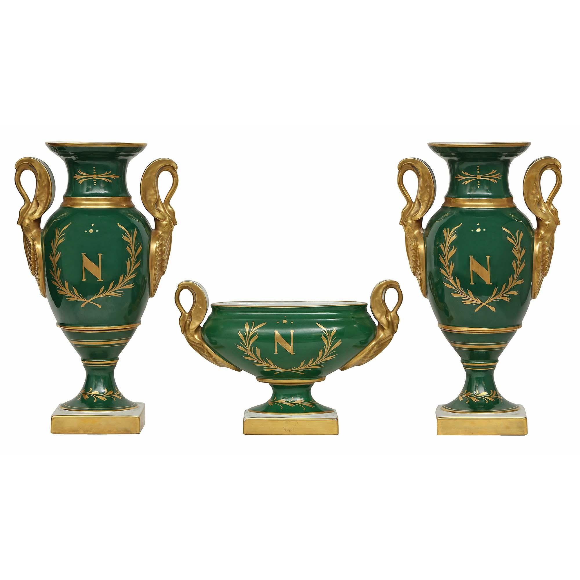 A very handsome 19th century French Empire st. three piece Limoges porcelain set, from Limoges, France. The three pieces, one bowl and two vases, are hand painted with wonderful scenes of soldiers, horses and gilt swan shaped handles. On the back of