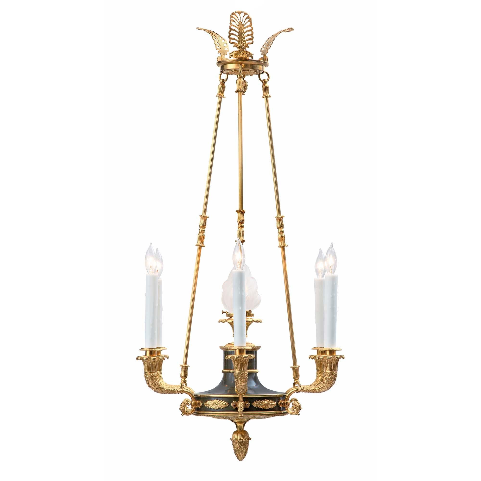 A handsome French 19th century Empire st. patinated bronze and ormolu seven light chandelier. The chandelier is centered by a fine ormolu acorn inverted finial below a richly chased base with most decorative foliate patterns in a striking satin and