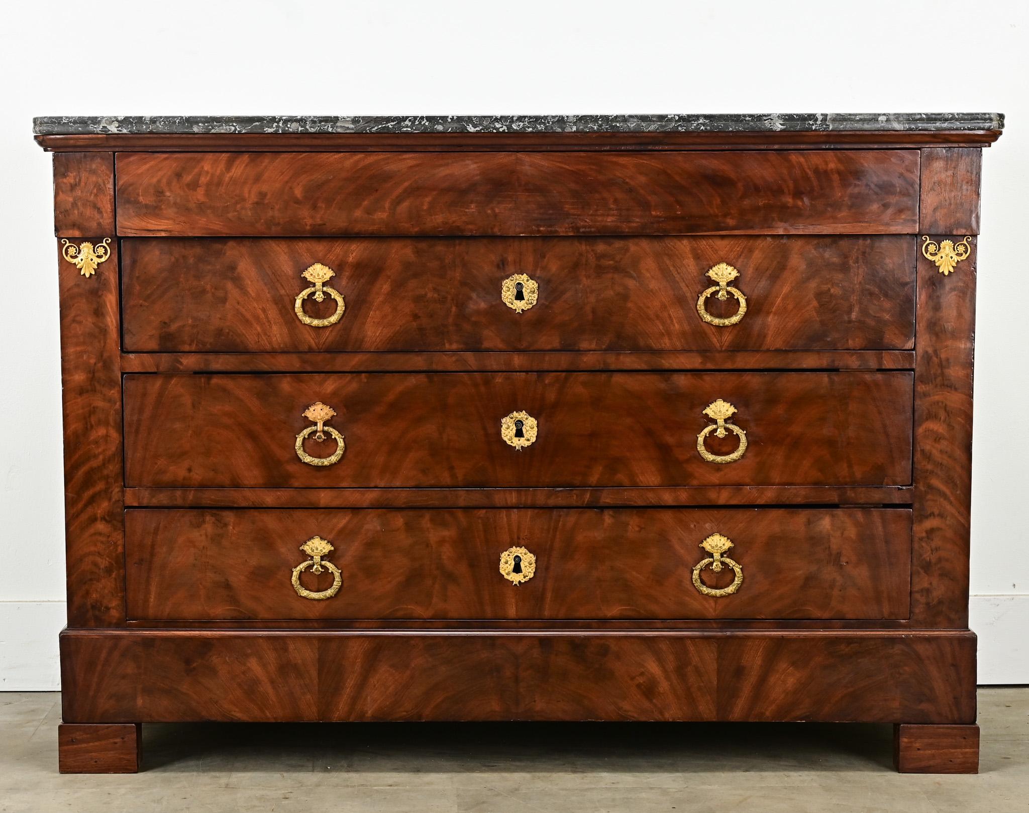 Una commode francese con piano in marmo, realizzata in mogano con radica e ormolatura stile Impero. Il piano della commode è in marmo di Sant'Anna con bordi anteriori curvi, per una superficie durevole e attraente. Il cassetto superiore è nascosto,
