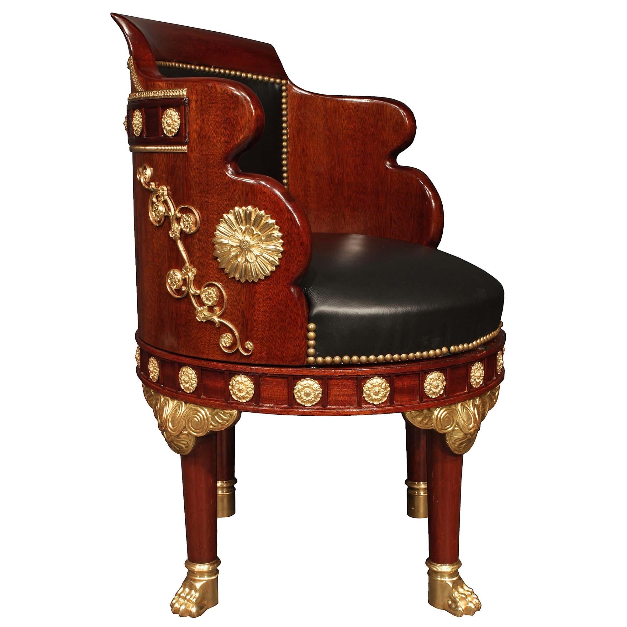 A very unique and handsome French 19th century Empire st mahogany and ormolu desk chair. This chair is raised by circular legs ending with ormolu paw feet and ormolu top mounts and can swivel from side to side. At the apron are recessed panels