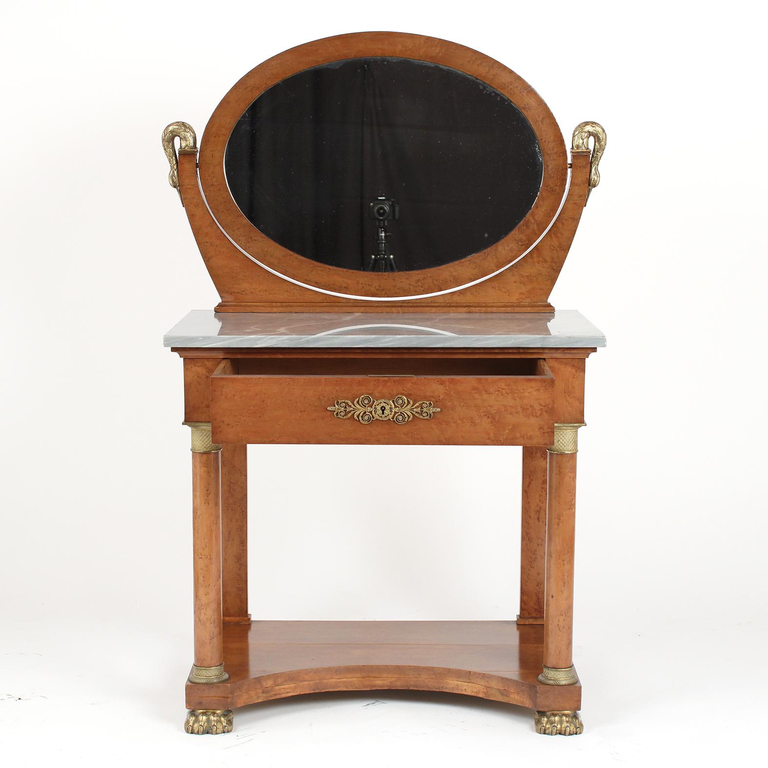 This French 19th Century Empire Style Vanity Table is made out of maple wood covered in a burled veneer with remarkable bronze accents decorations and is in very good condition. This Vanity has been professionally restored preserving its original