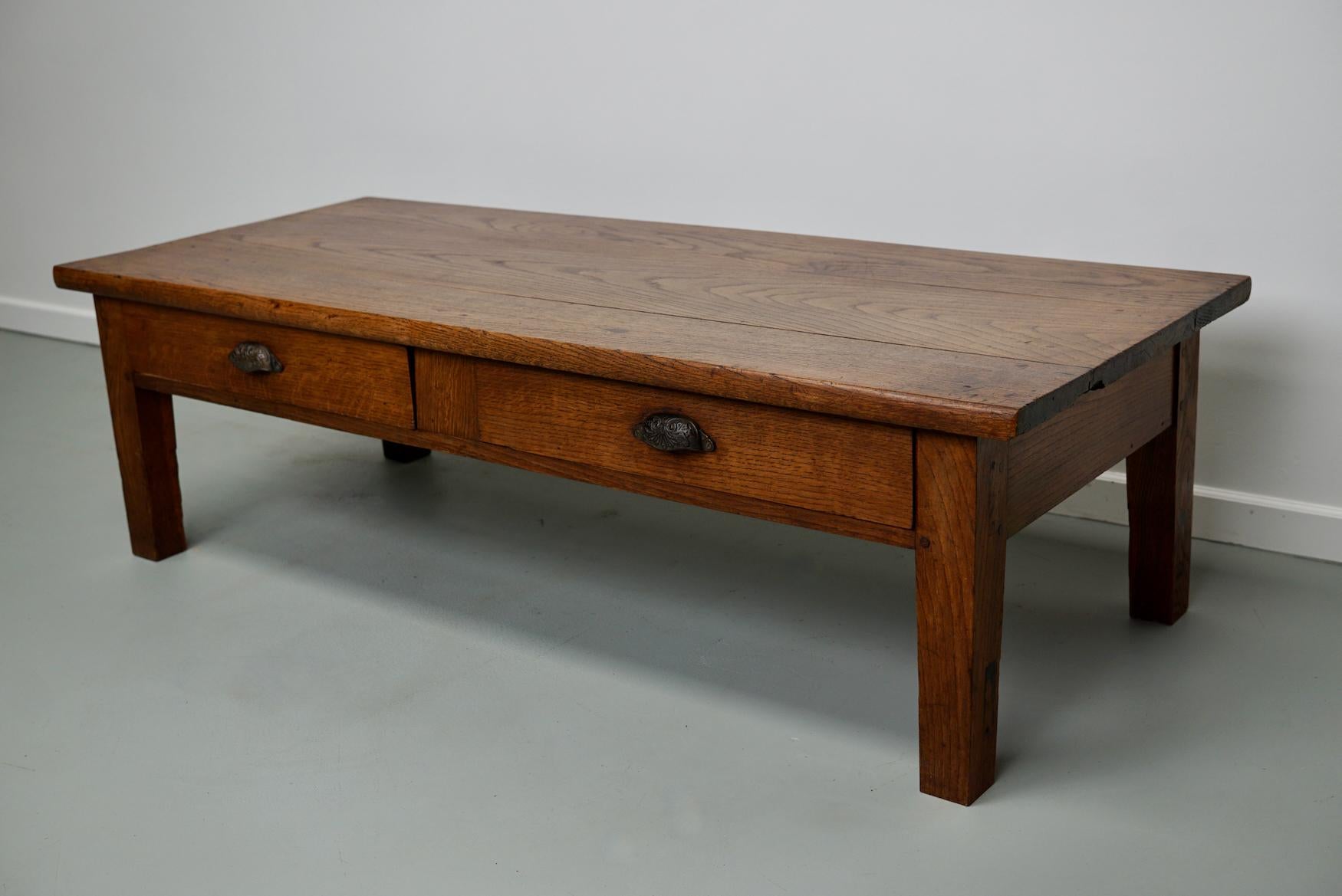 This coffee table was converted from an old 19th century oak farmhouse kitchen table. It retained a very nice patina and rich color over the years and has a practical size.