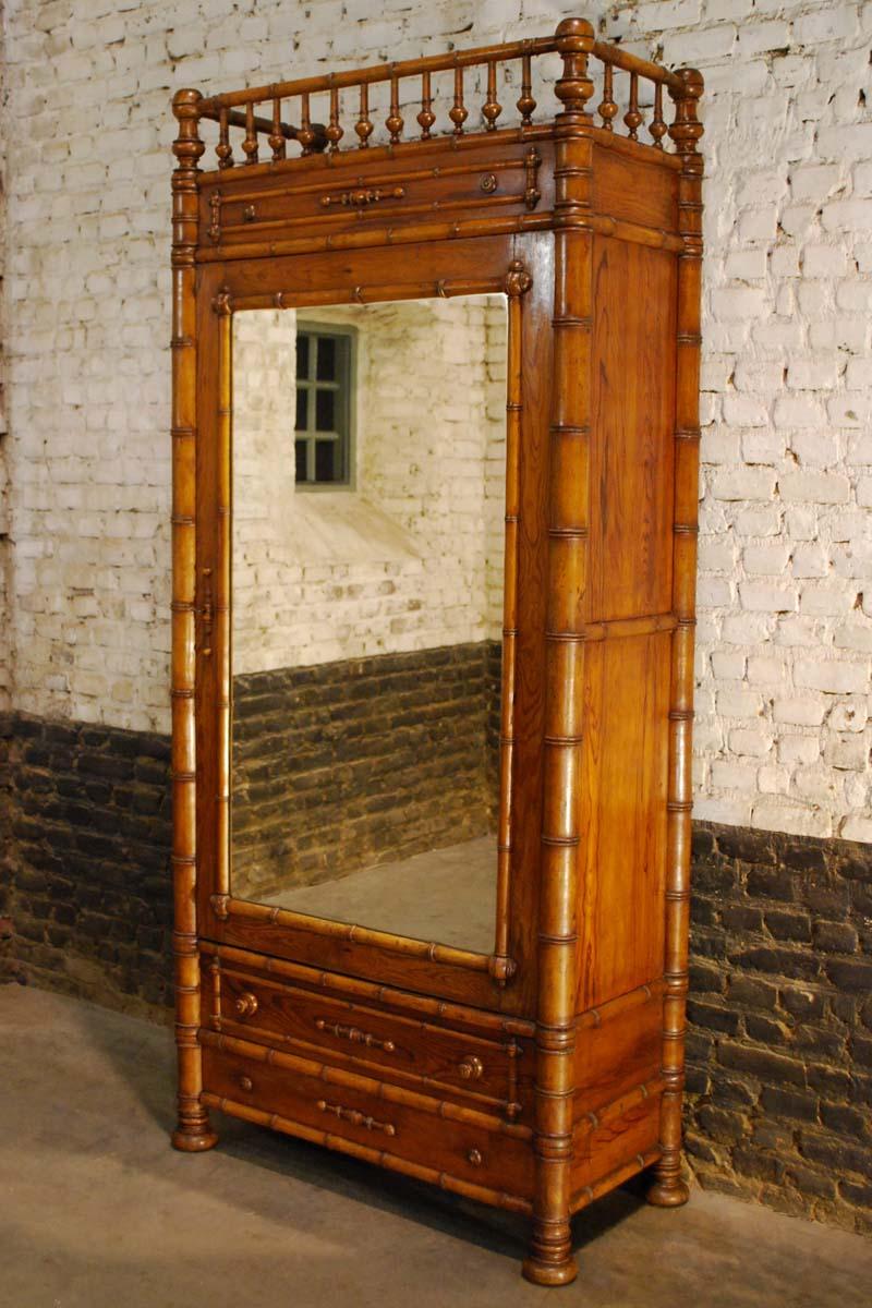 French antique faux bamboo armoire, made at the end of the 19th century. This beautiful one door cabinet has a mirrored door with an authentic thick mirror plate. Below the door, there is one drawer. The faux bamboo is made from turned rich mellow