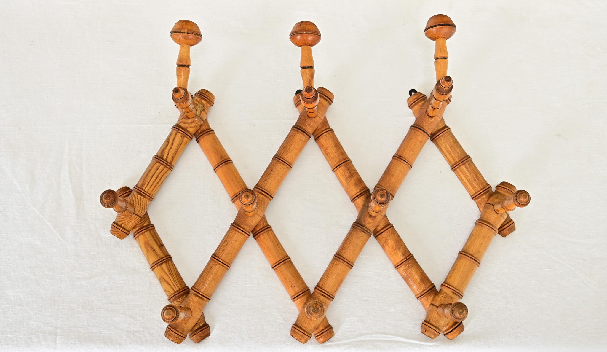 Delightful French late 19th century faux-bamboo carved fruitwood accordion hat & coat rack for mounting on a wall. Perfect for an entryway, the piece is adjustable from 7-49” wide, creating an argyle effect of three diamond-shaped components fitted