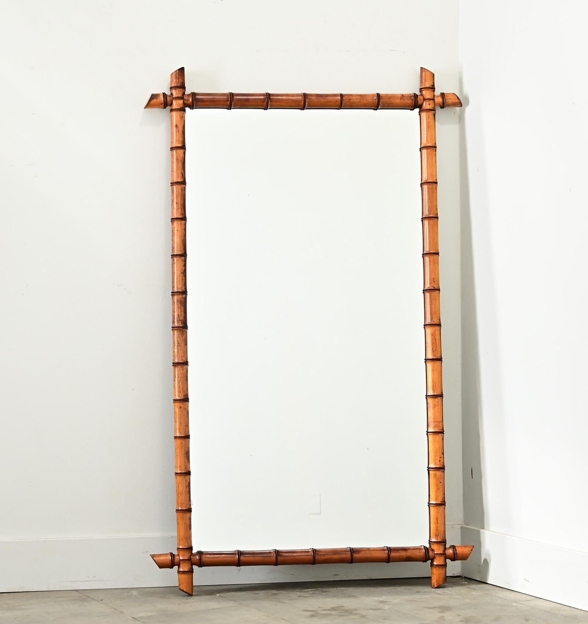 Espejo de imitación de bambú procedente de Francia, de principios de siglo, hacia 1890, con una preciosa pátina marrón ámbar en el marco. Este espejo alto presenta proporciones rectangulares y simetría para colgar en cualquier dirección, hecho de