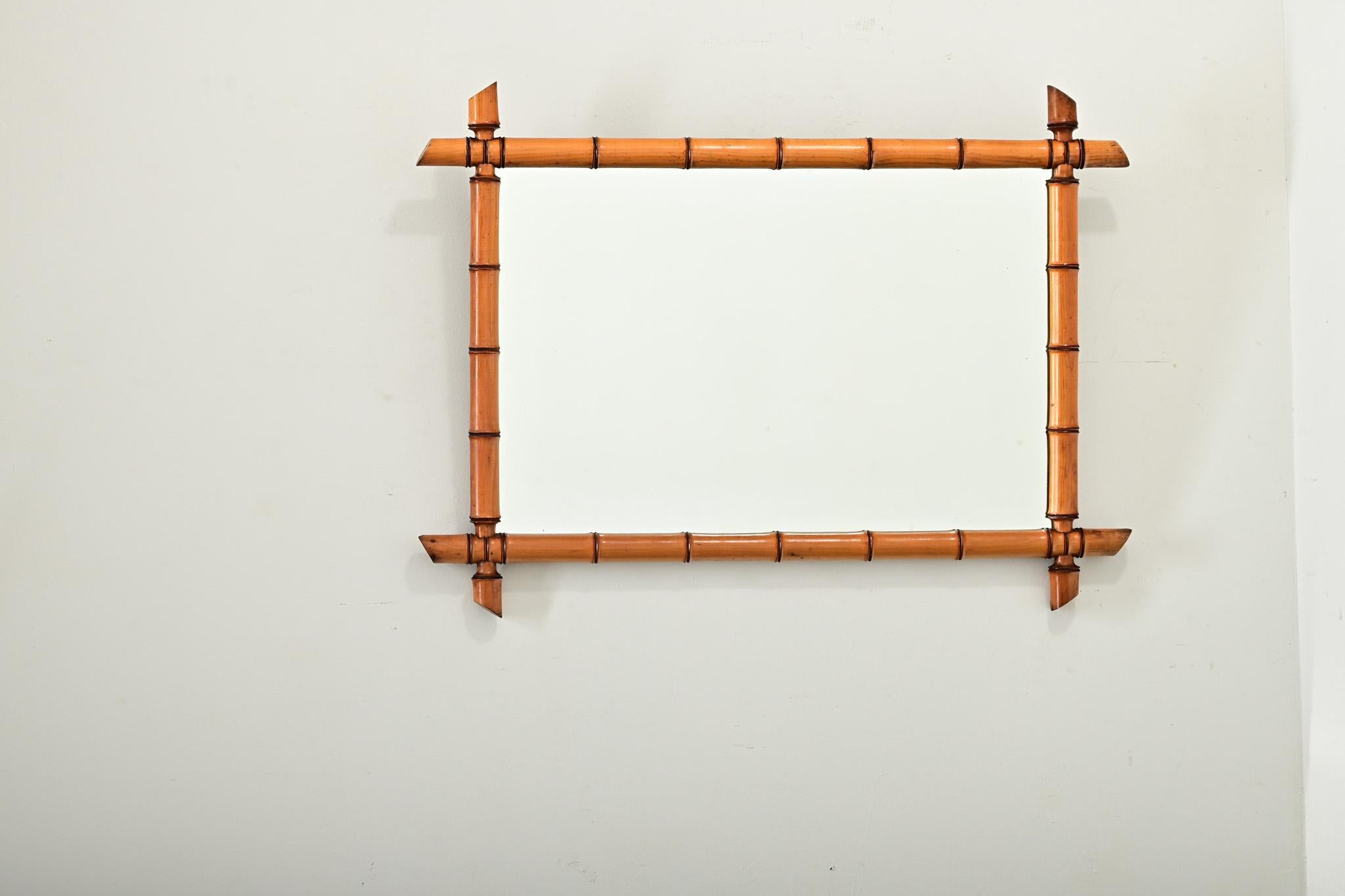 Ein Spiegel aus geschnitztem Kiefernholz mit gedämpften Maserungen, die bis zu den unterbrochenen, an den Ecken hervorstehenden Knoten als (falscher) Bambus erscheinen, aus Frankreich, Jahrhundertwende um 1890. Dieser vertikal ausgerichtete Spiegel