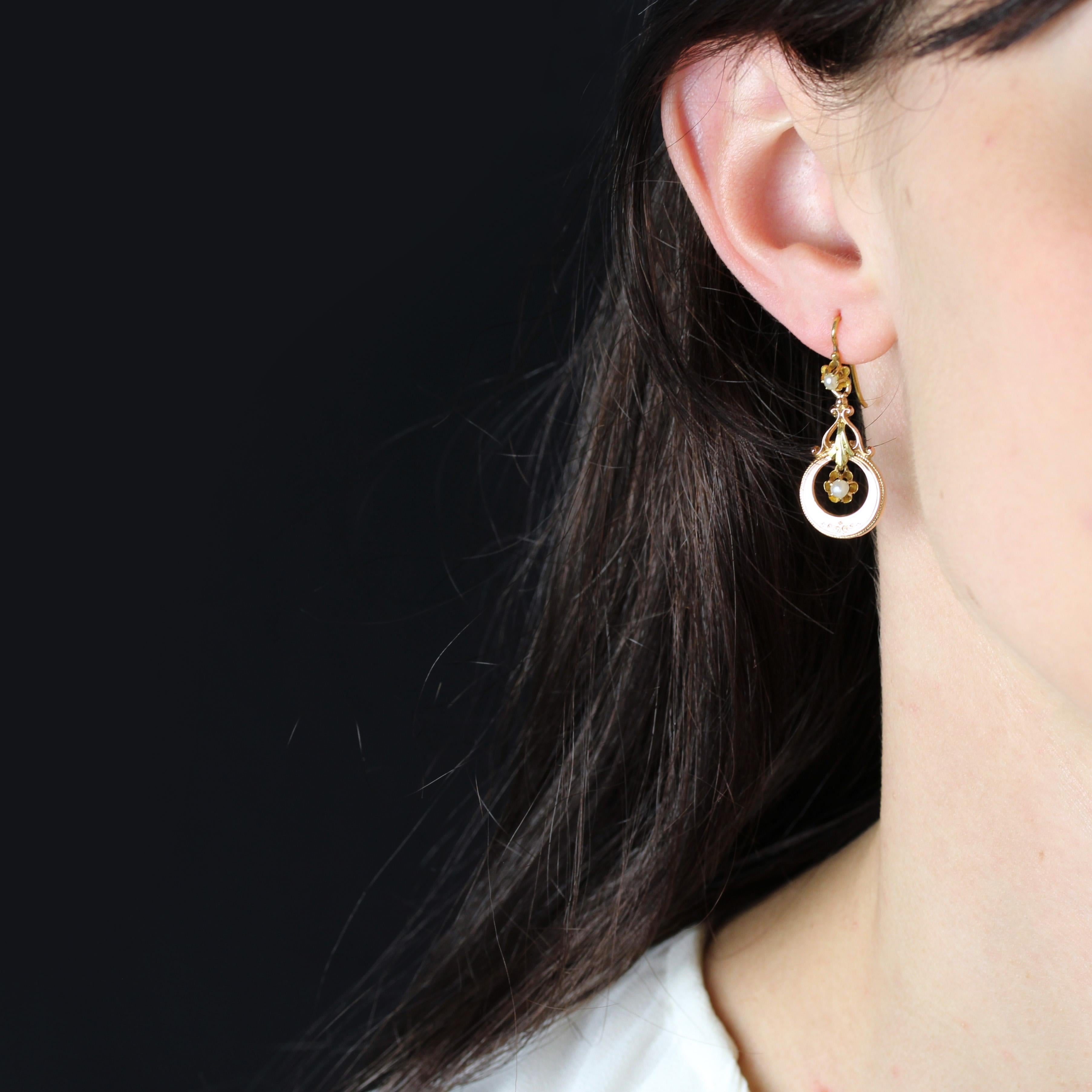 For pierced ears.
Pair of earrings in 18 karat rose and green gold, eagle's head hallmark.
Feminine and slender, these dangling earrings feature a fine pearly white orient pearl held in a claw-set setting that supports an arabesque motif and a