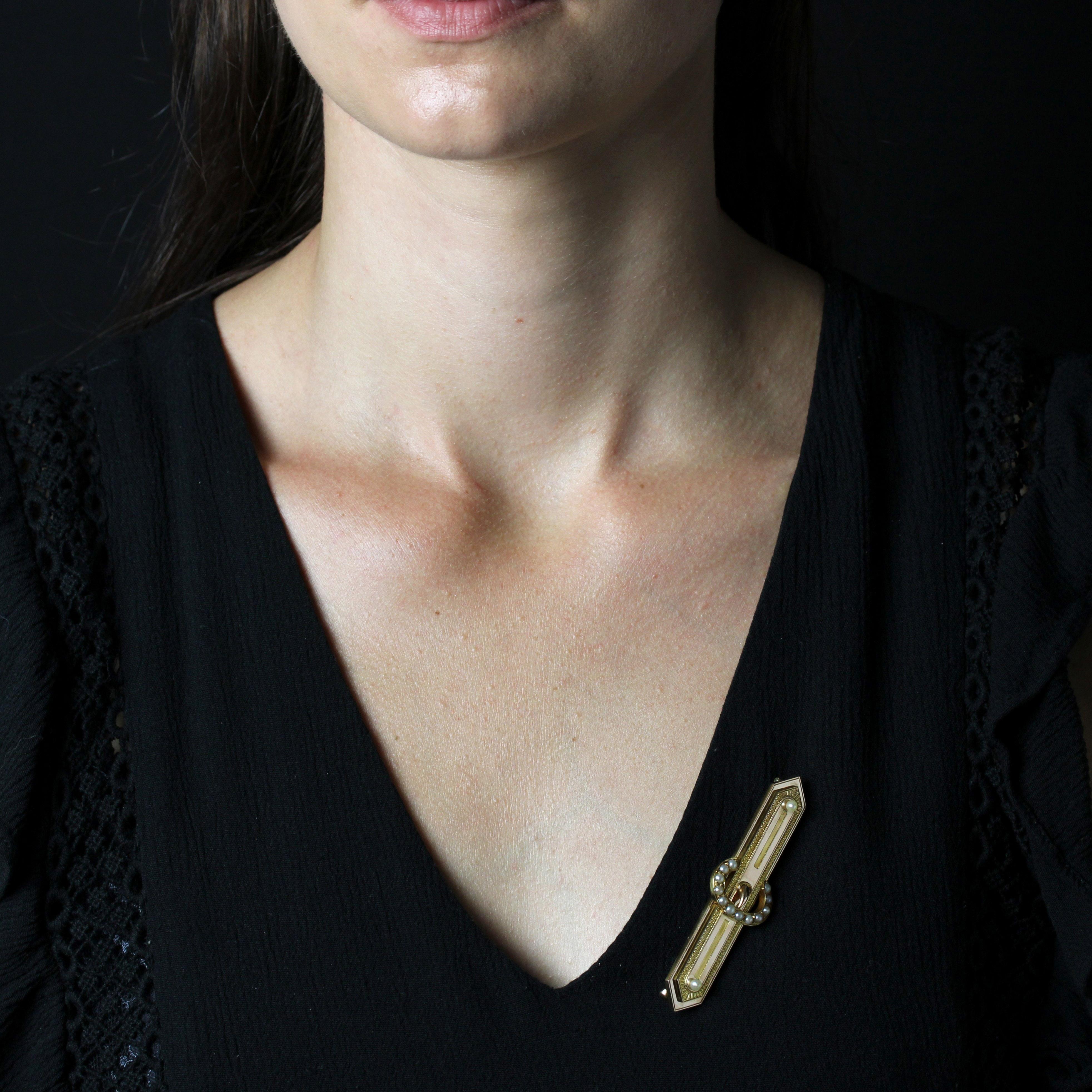 Brooch in 18 karat rose gold, eagle head hallmark.
This elegant rose gold brooch is elongated, hexagonal and delicately chased, with 2 fine button pearls at the ends and a belt buckle motif in the center adorned with fine half-pearls. The clasp is a