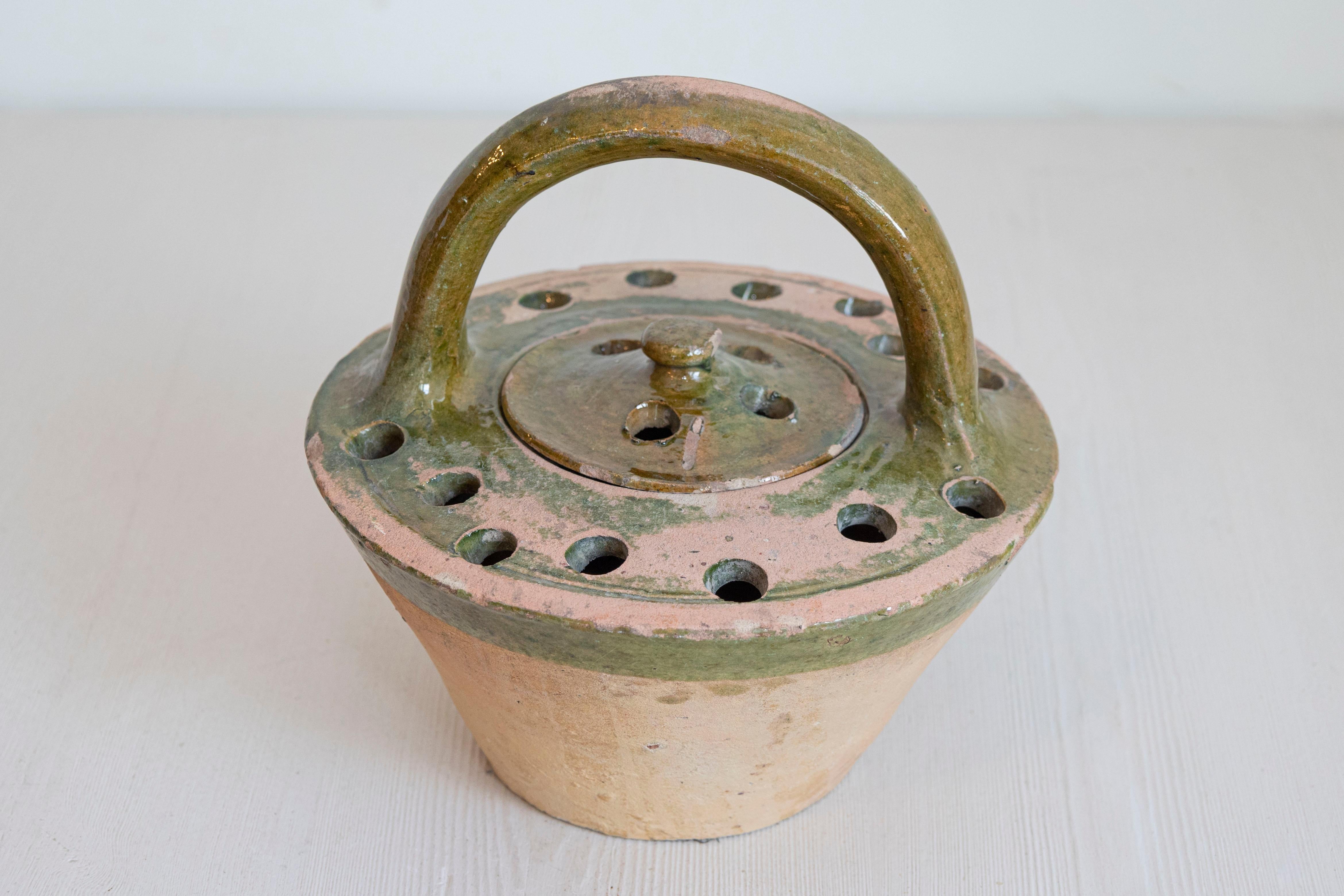 Réchaud en terre cuite et émail vert du 19e siècle, avec couvercle, grande poignée et petits trous sur le dessus. Cette chaufferette en terre cuite française du XIXe siècle et en poterie émaillée verte est un remarquable témoignage de la forme et de