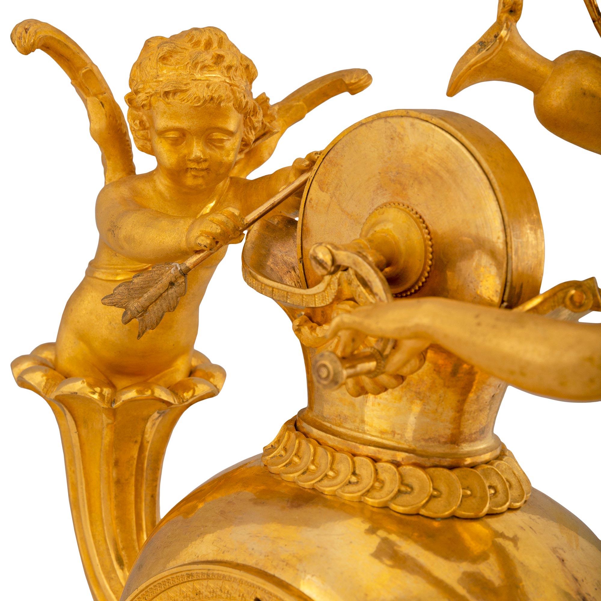 Remarquable pendule française du début du XIXe siècle en bronze doré Premier Empire, avec le mouvement original à fil de soie, daté de 1809. Il repose sur une plate-forme carrée moulée en bronze doré, au-dessus de supports en forme de petits pains.