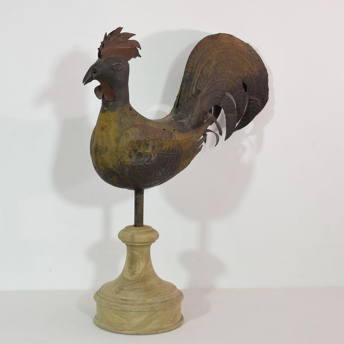 Beautiful iron weathervane representing a rooster or cockerel,
France, 1850-1900. The weathervane is placed on an oak pedestal of later date
Weathered and small losses. Measurement here below is inclusive the wooden base.