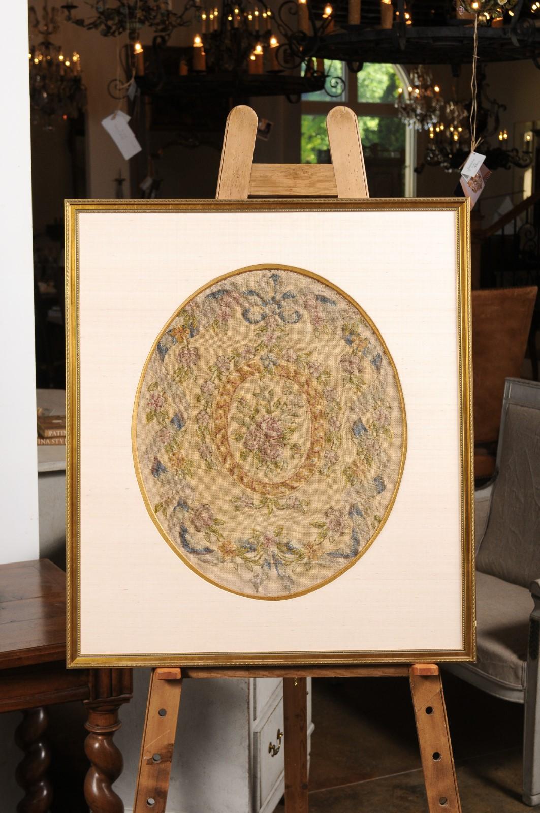 A French Aubusson floral oval tapestry from the 19th century with carved rectangular giltwood frame. Born in the famous Aubusson manufacture located in central France during the 19th century, this framed tapestry features a floral decor depicting a