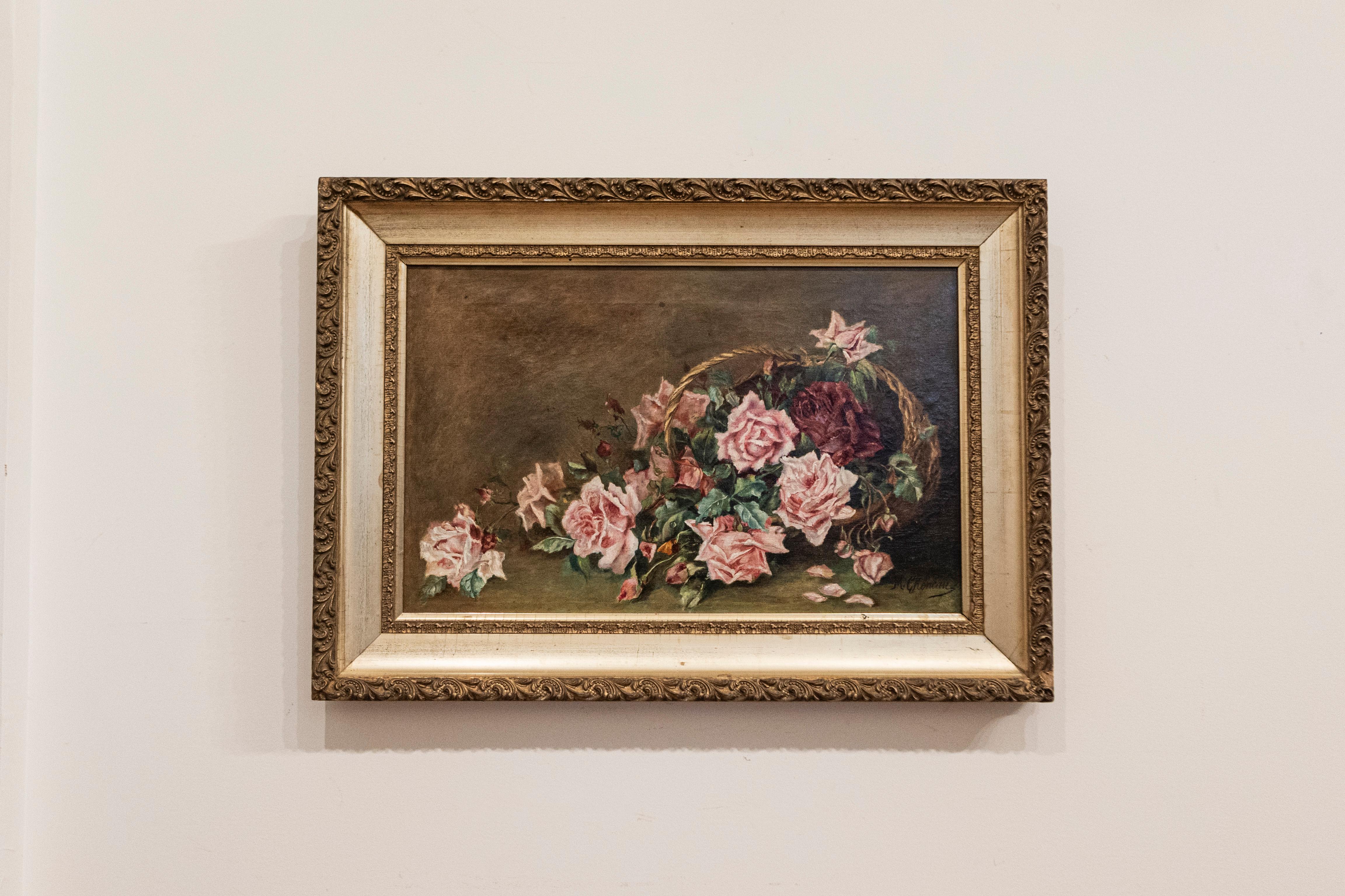 A French framed oil on canvas floral painting from the 19th century, depicting roses. Born in France during the 19th century, this exquisite oil on canvas painting features a delicate bouquet of pink roses falling on a tabletop from a tipped over