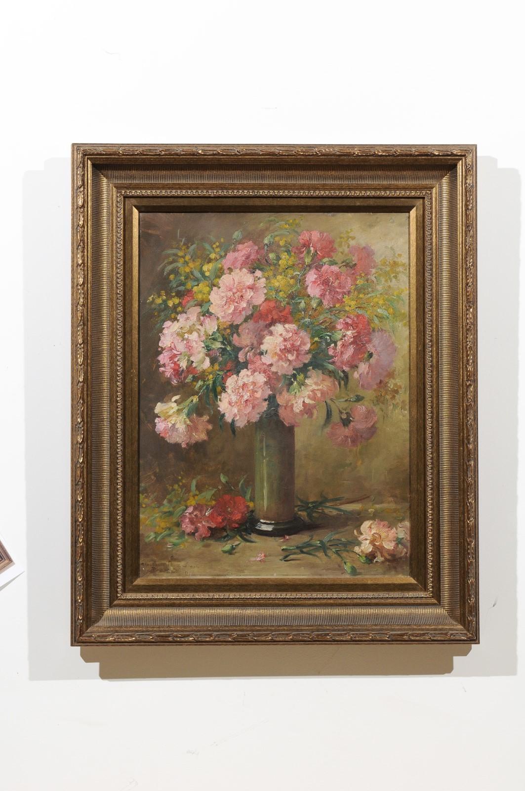 A French floral still-life oil on canvas painting from the 19th century, set inside a giltwood frame. This French still-life painting features an exquisite bouquet of pink flowers displayed in an elegant tall vase. The various shades of pink that
