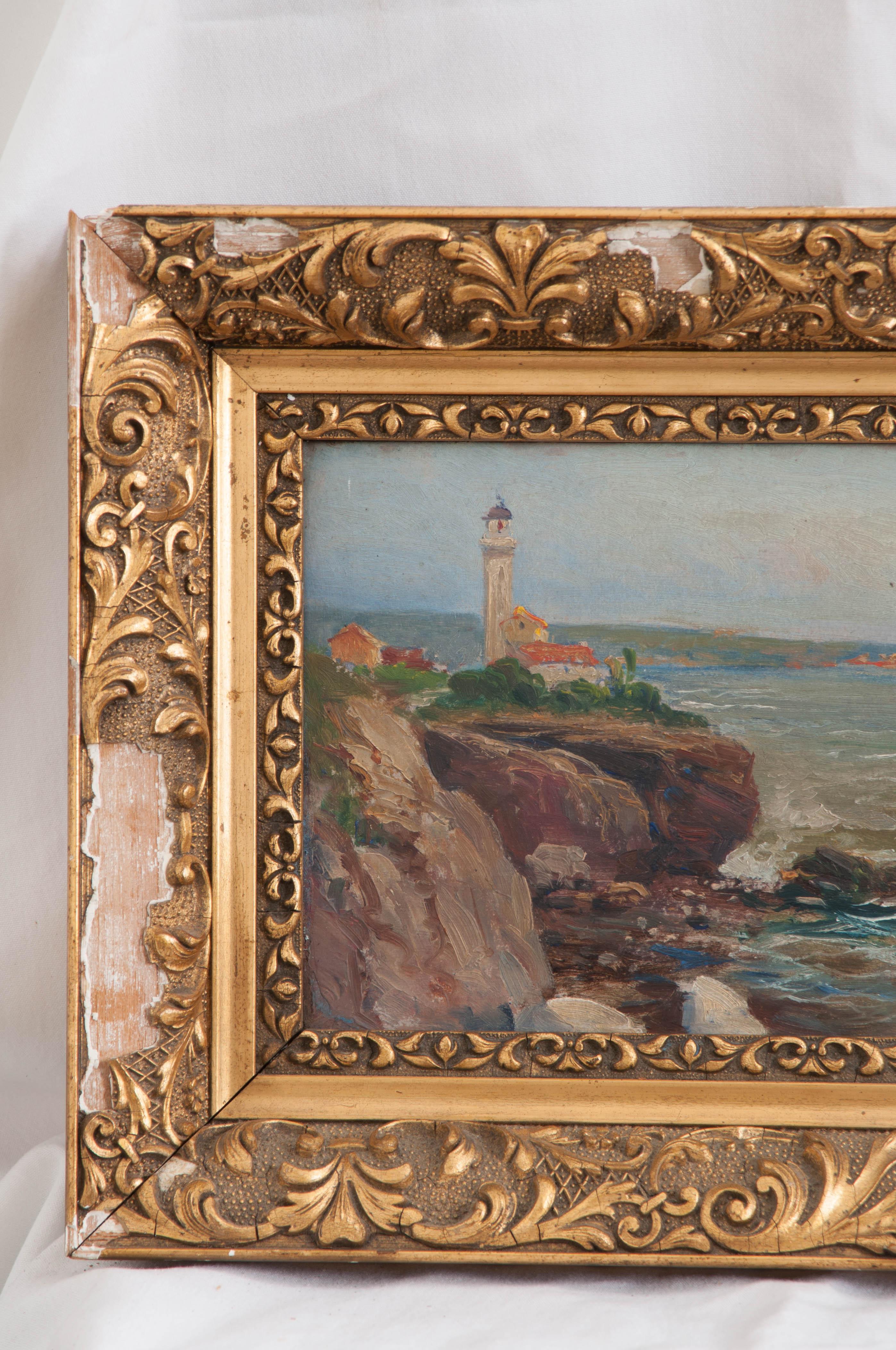 French oil painting on board of a seaside and lighthouse is surrounded by a distressed and decorative plaster, gilt frame. Signed by the artist, G. Cogneen.