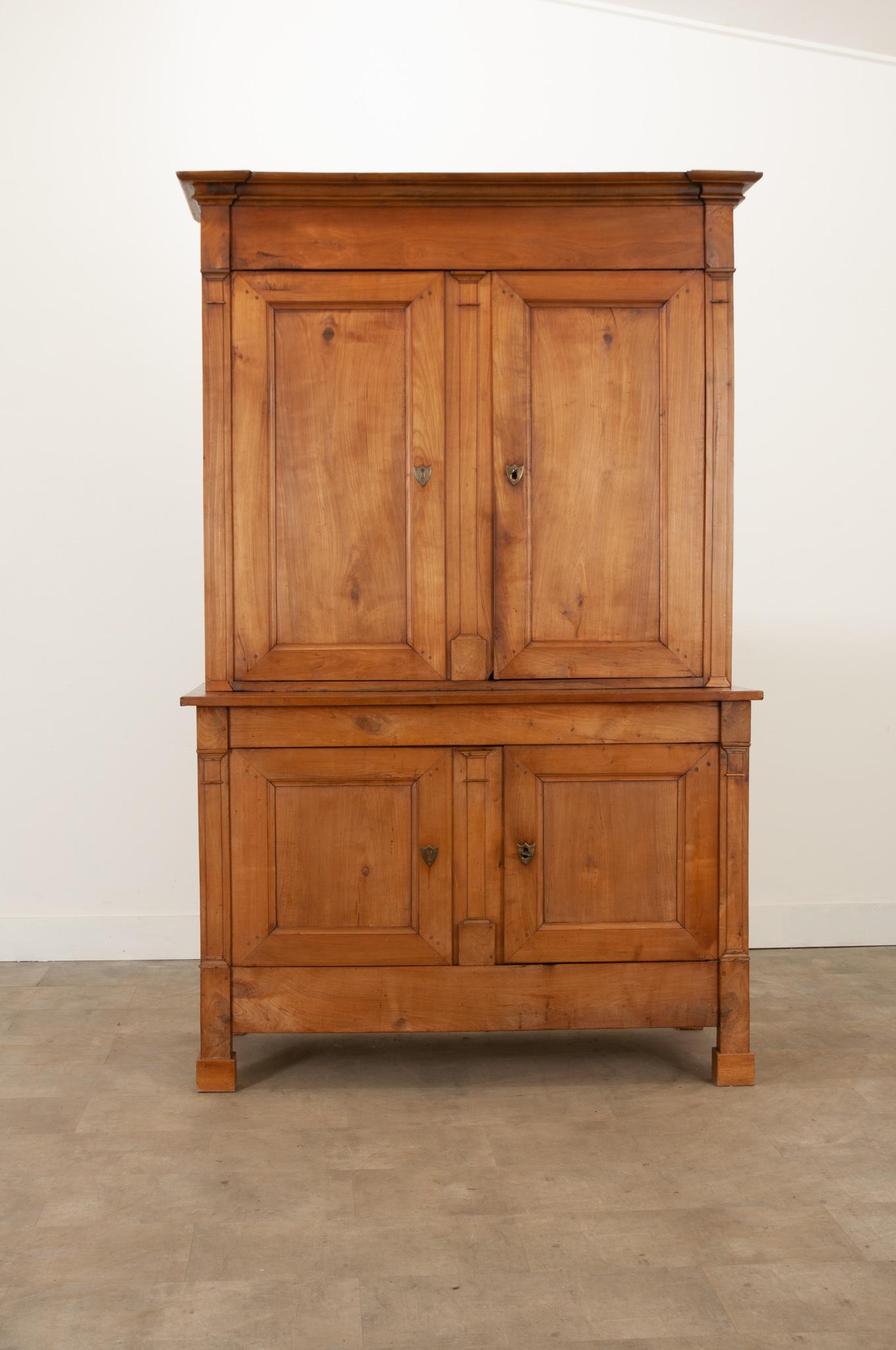 A fantastic fruitwood Buffet A Deux Corps from France, crafted during the 1850s. A sharp cornice surmounts a pair of paneled doors with brass escutcheons and a functioning lock. The tops’ interior houses four removable shelves that measure 12-½”