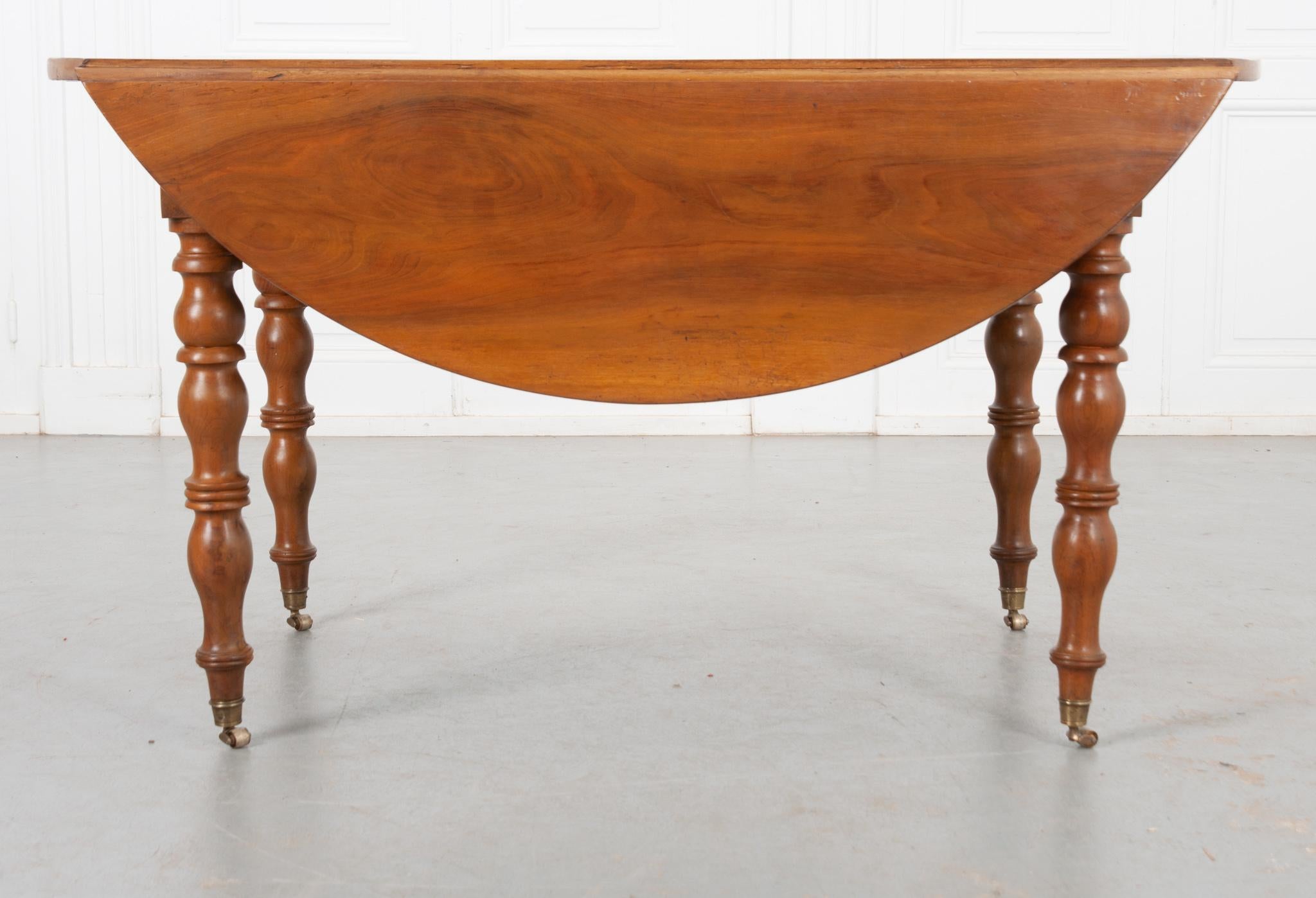 This French 19th century drop leaf table is made from wonderfully smooth fruitwood! It opens into a circular shape with the leaves up and fits approximately four chairs. When the leaves are down it would be great behind a sofa and measures 27-¾”H x