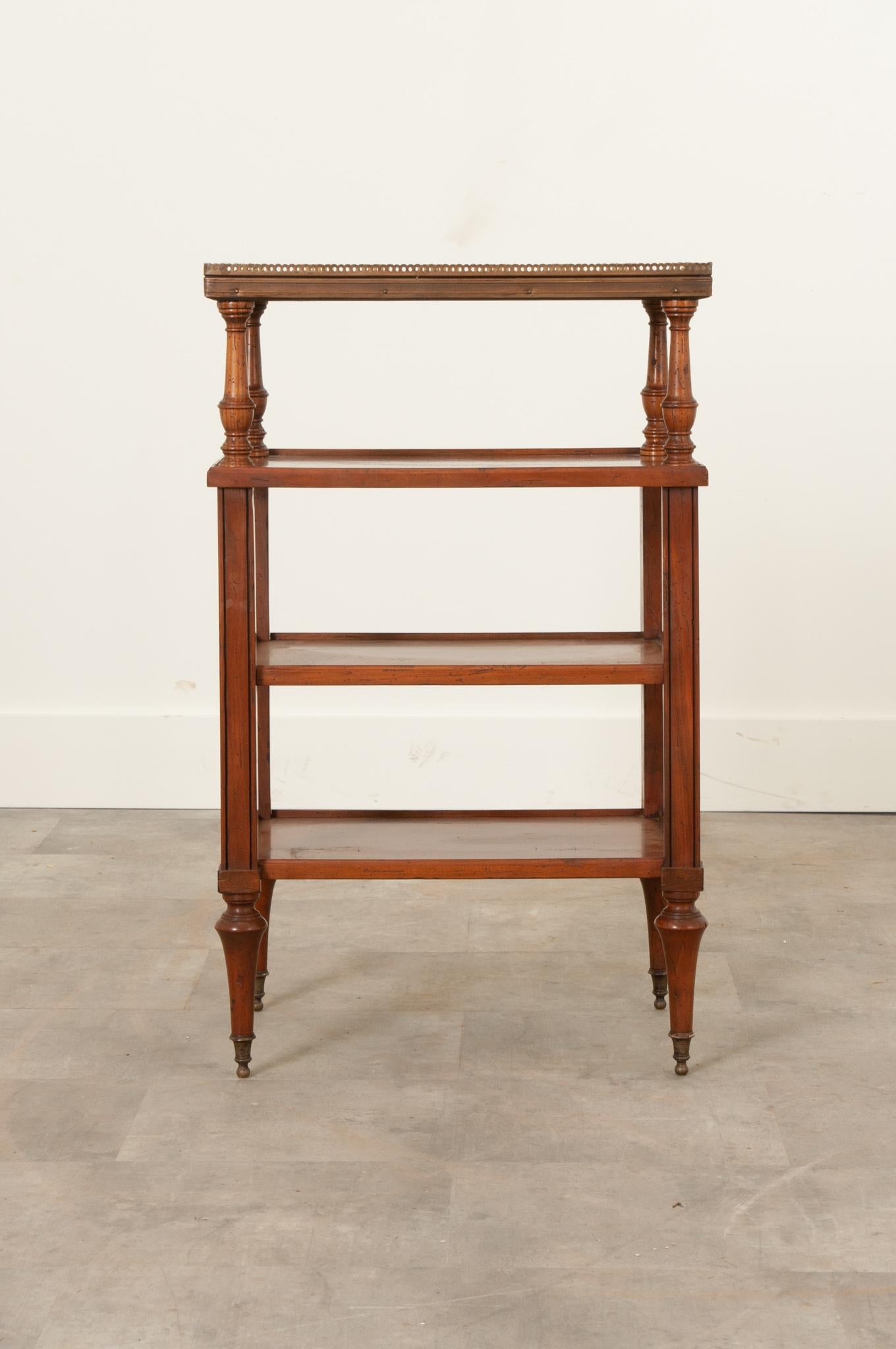 A fantastic fruitwood etagere from 19th century France. This tiered table has four total shelves, with the topmost being made of marble and surrounded by a pierced brass gallery. It is lifted by beautifully turned column-form supports. Beneath are