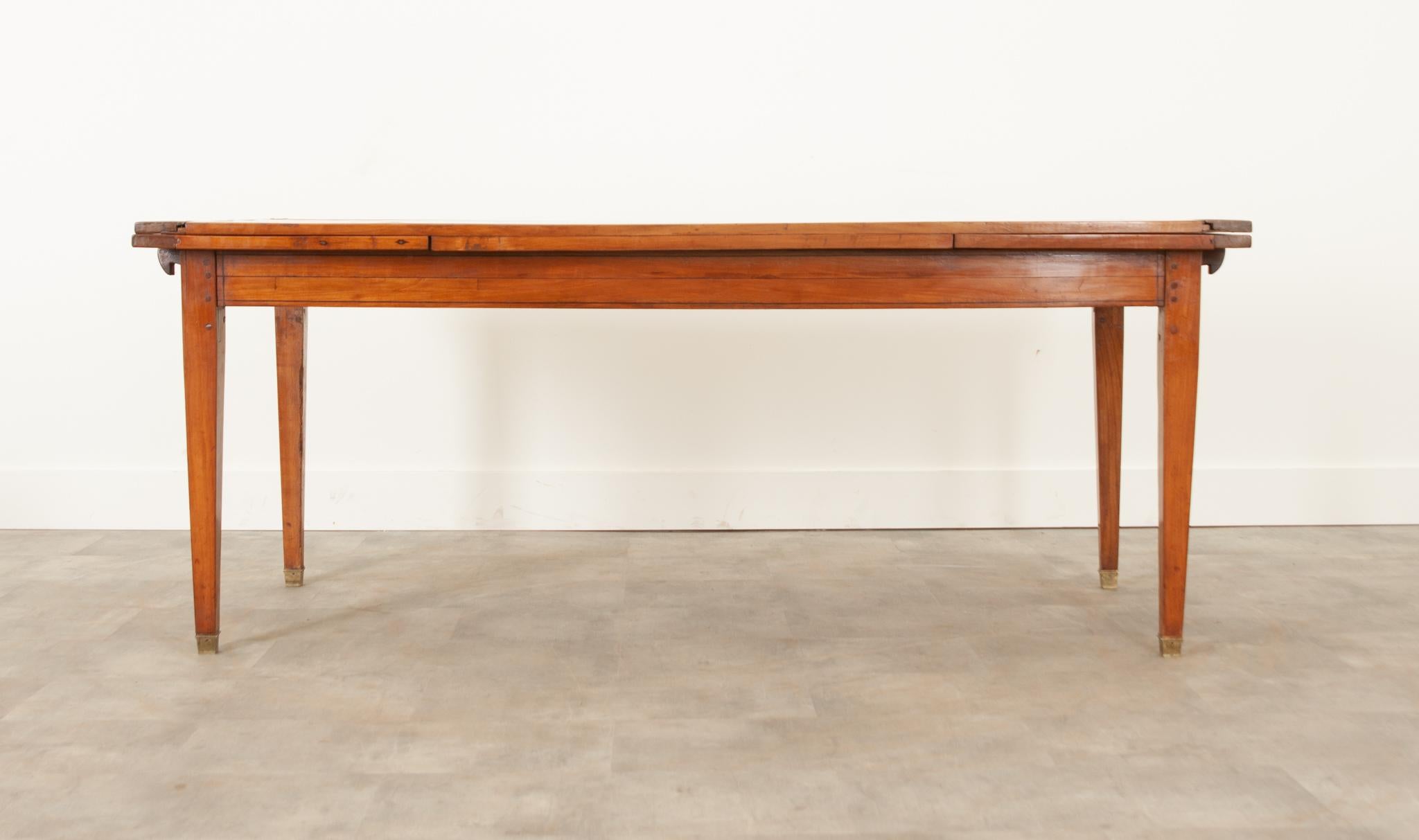 A gorgeous extended dining table from 19th century France. The vibrant fruitwood has gained a wonderful patina over the years and will effortlessly add so much character to your dining area. A narrow inlay of darker wood adds a nice touch of