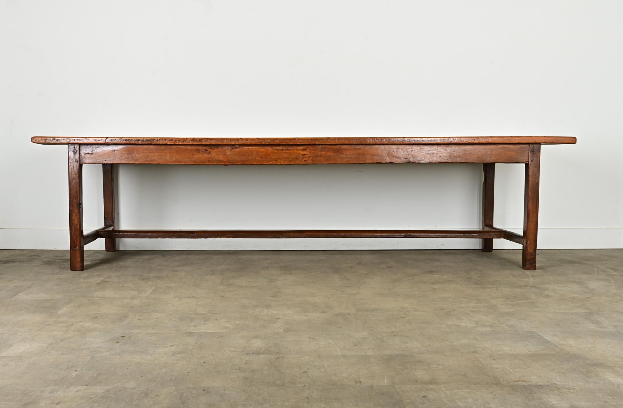 D'une longueur de près de trois mètres, cette table de ferme française du XIXe siècle présente un grain et une patine attrayants dans les planches massives. Le plateau en bois fruitier, d'une épaisseur de 1 ⅜