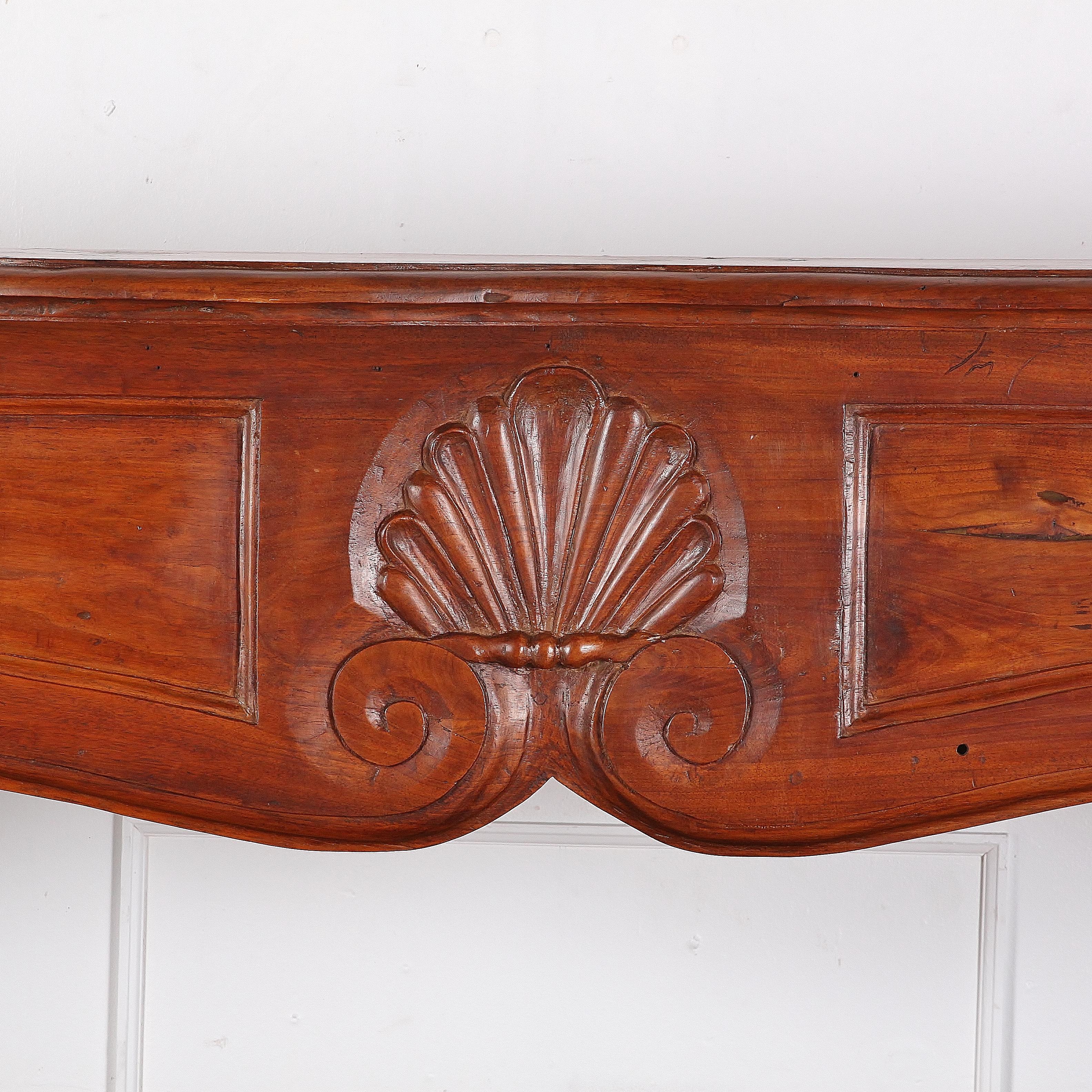 A large, 19th century, French solid fruitwood mantel (fireplace) with Louis XV-style carved details.

The piece has been modified to serve as a bookcase with the addition of some shelves but these are easily removed. 

 