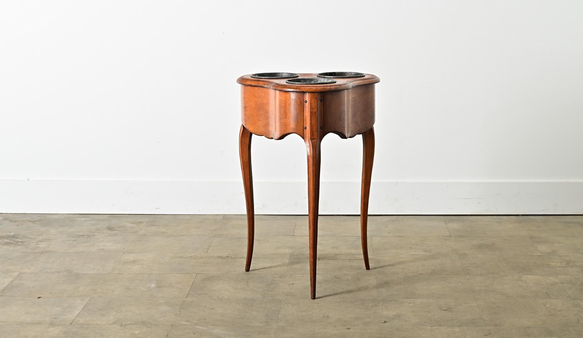 A French, Louis XV-style fruitwood rafraîchissoir table from circa 1870. Functioning like a dry bar, it is a practical little side table adapted to keeping refreshments cold by placing them in removable ice buckets set flush within the cabinetry.
