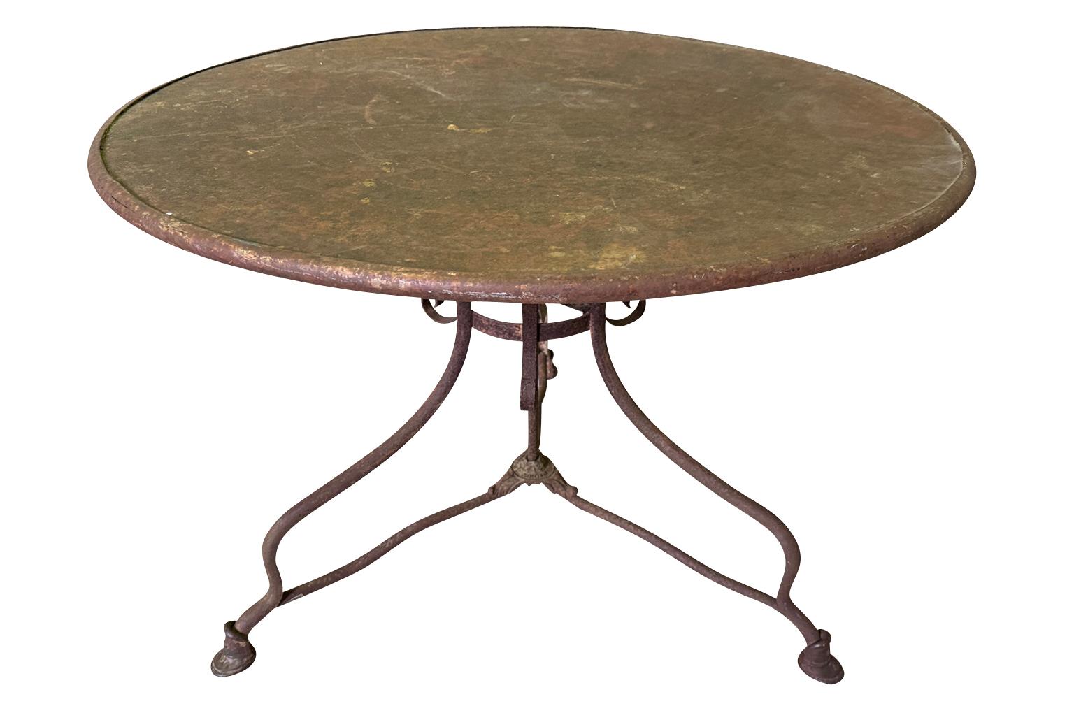 A lovely French 19th century Garden Gueridon from Arras, France.  Soundly constructed from painted iron with the manufacturer's plate.  Nice larger scale.  Wonderful as a breakfast table or game table.