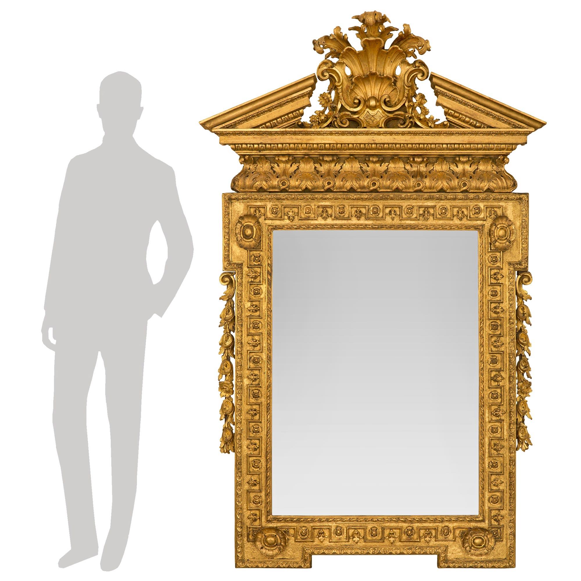 A sensational and large scale English early 19th century George I st. giltwood mirror circa 1820. The mirror retains its original mirror plate set within a stunning and most decorative frame with a fine twisted ribbon band and superb wrap around