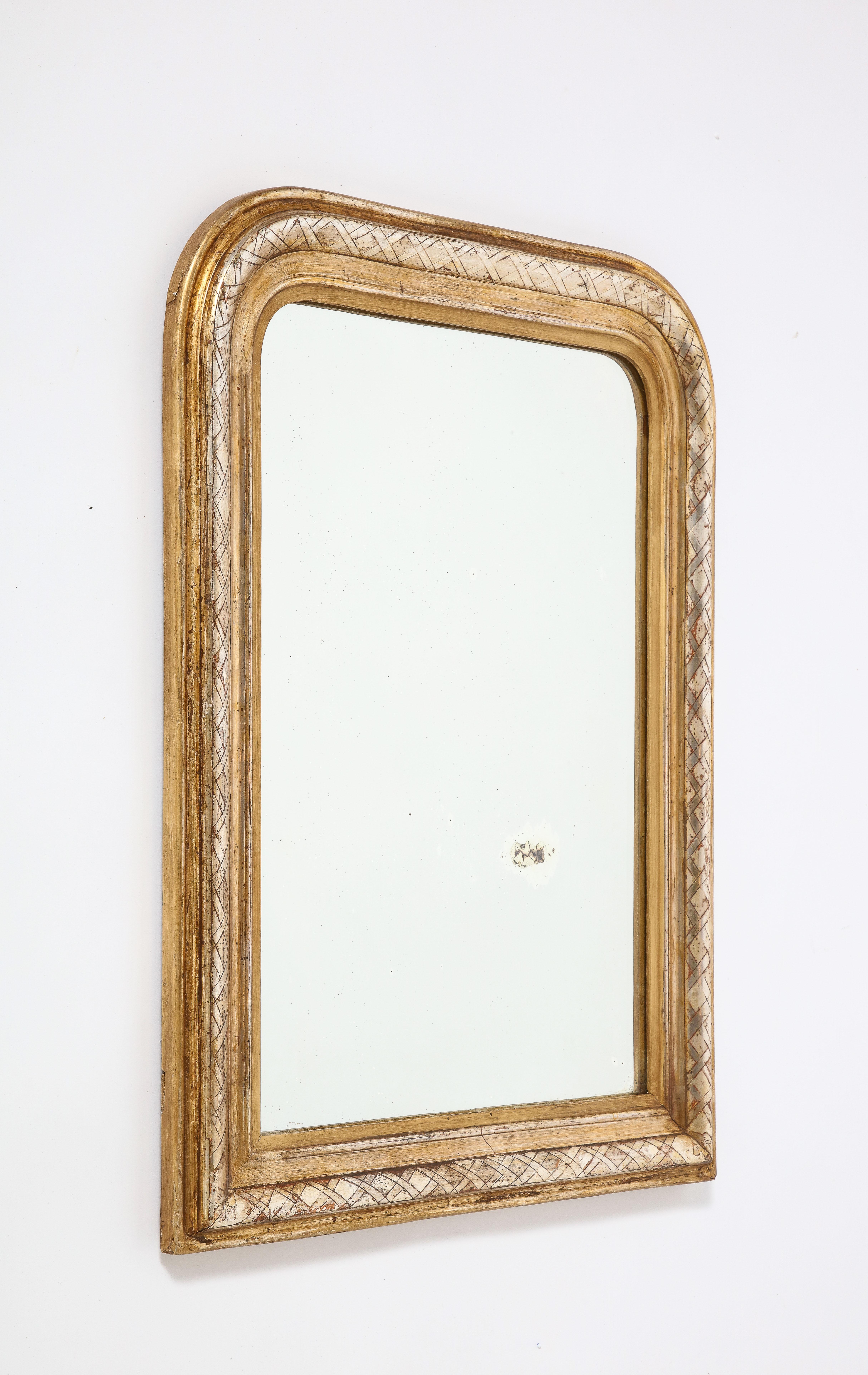 An early very fine French Louis Philippe carved and gilded mirror with cross-hatch motif on the inner molding and traces of silver gilt.  Original glass plate and wood backing. 
An exceptional example of the period with real gilding and in excellent