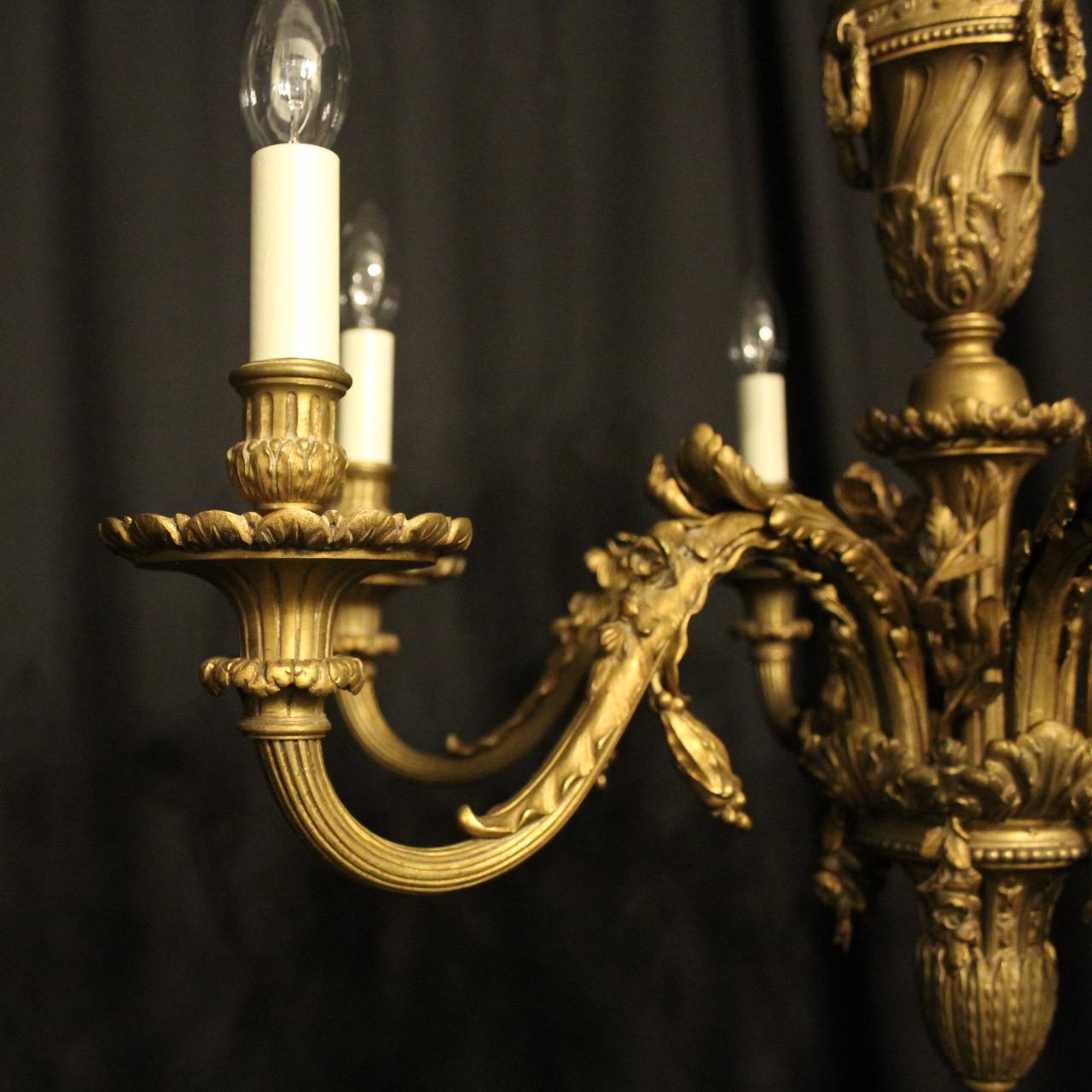 A quality French gilded cast bronze 6-light antique chandelier, the ornate leaf clad scrolling arms with reeded trumpet bobeche drip pans and bulbous candle sconces, issuing from an elongated central urn column with four laurel rings and super leaf