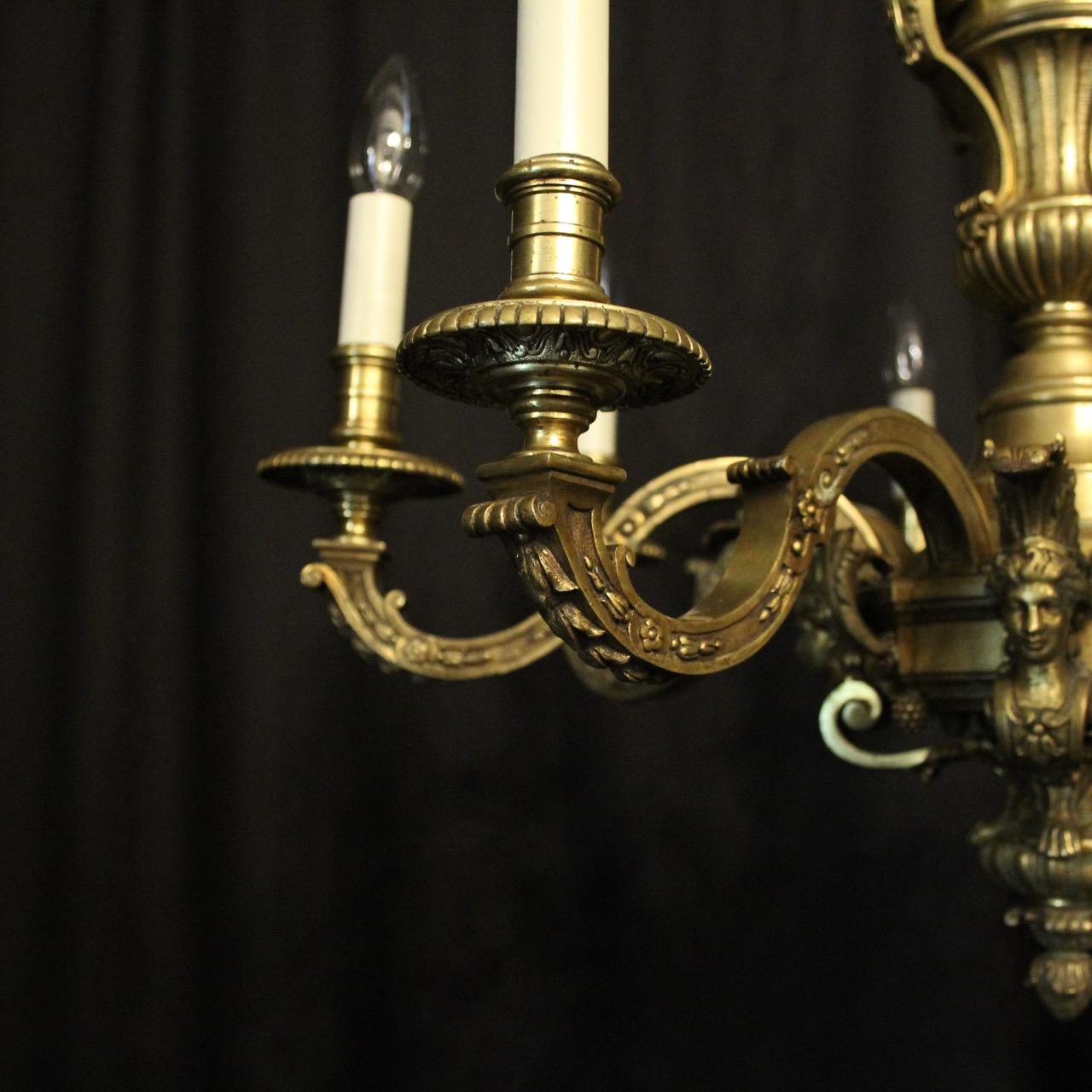 A French gilded cast bronze 8-light antique chandelier in the manner of Andre Charles Boulle, the leaf clad square gauge scrolling arms with ornate circular bobeche drip pans and candle sconces, issuing from a pierced central urn stem with four